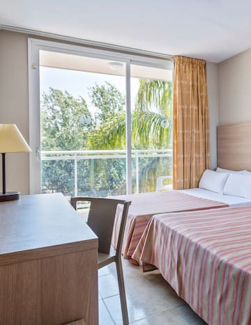 a room with two beds and a table and a lamp