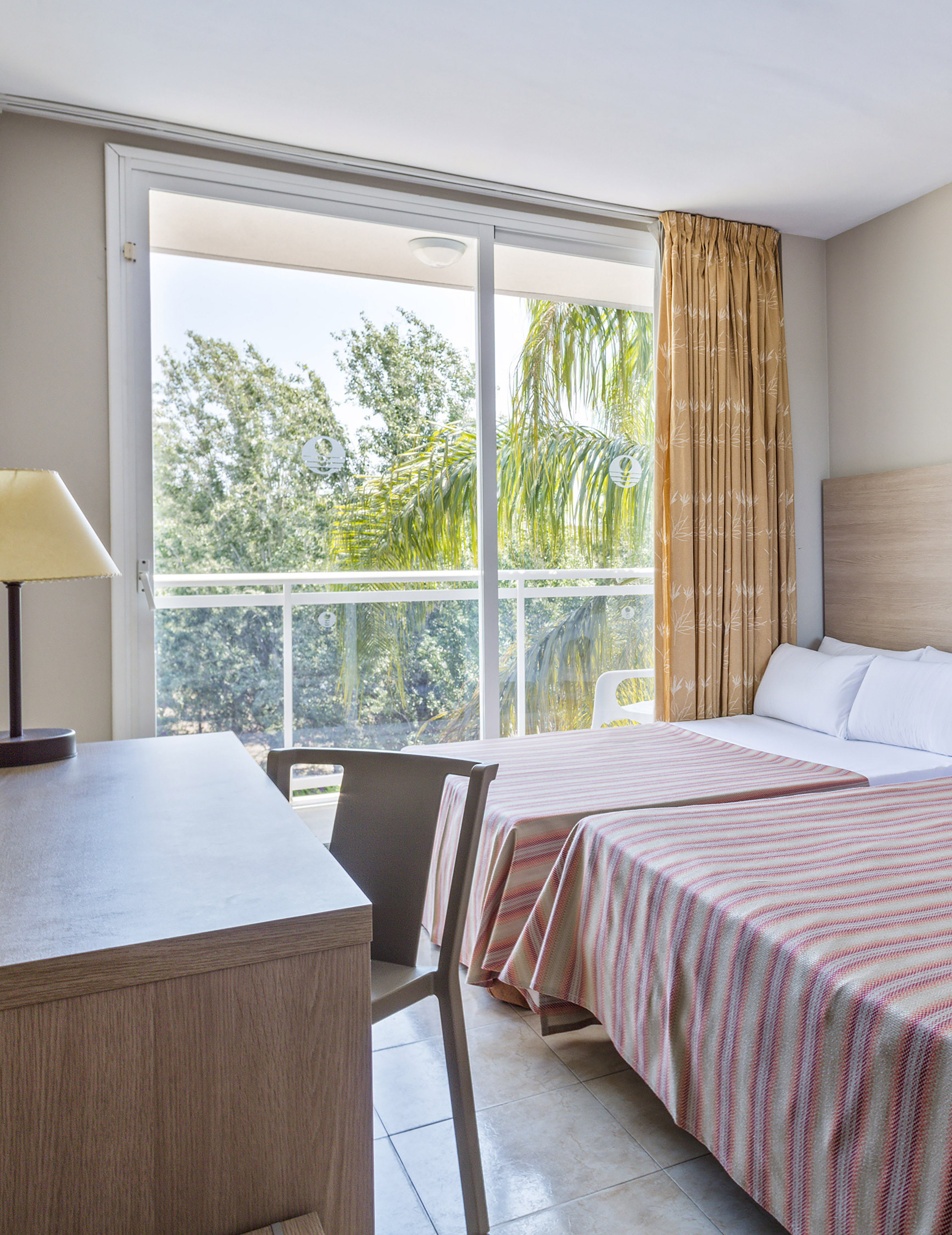 a room with two beds and a table and a lamp