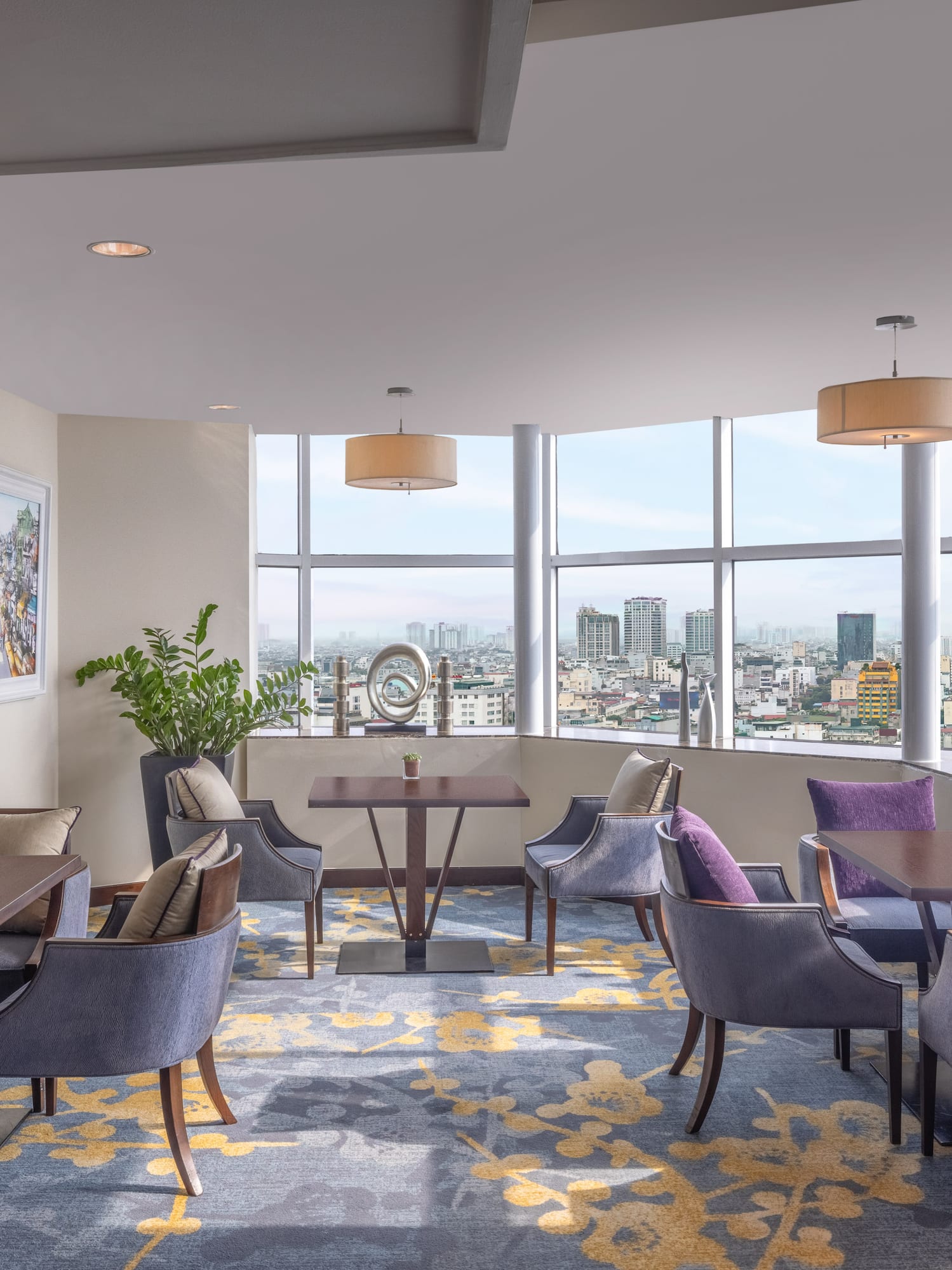 a room with tables and chairs and a view of a city