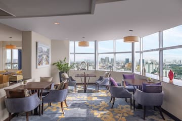 a room with tables and chairs and a view of a city