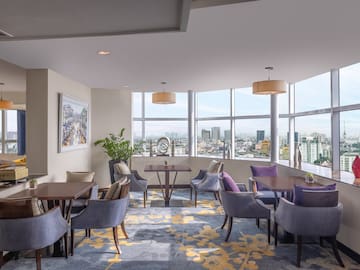 a room with tables and chairs and a view of a city