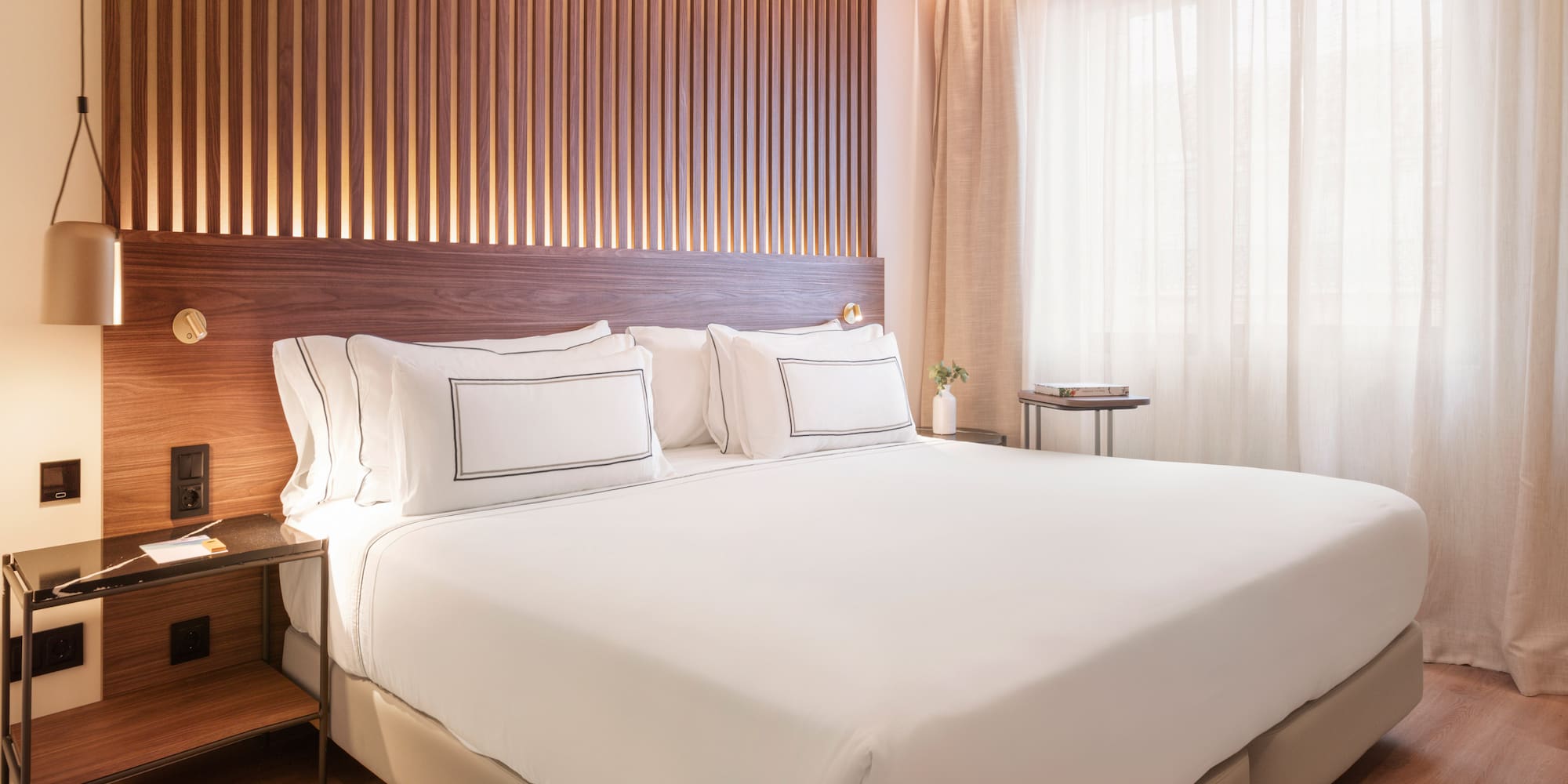 a bed with white sheets and a wood paneled wall