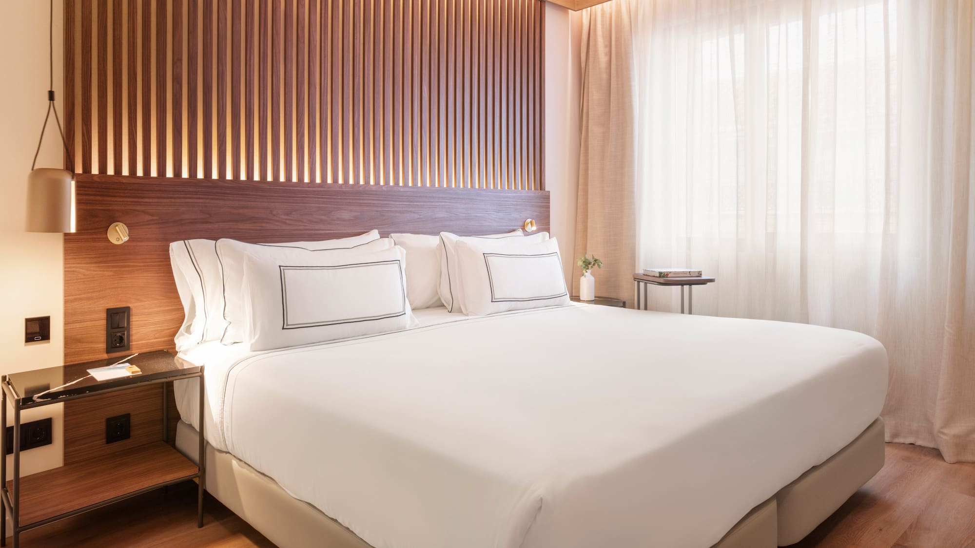 a bed with white sheets and a wood paneled wall