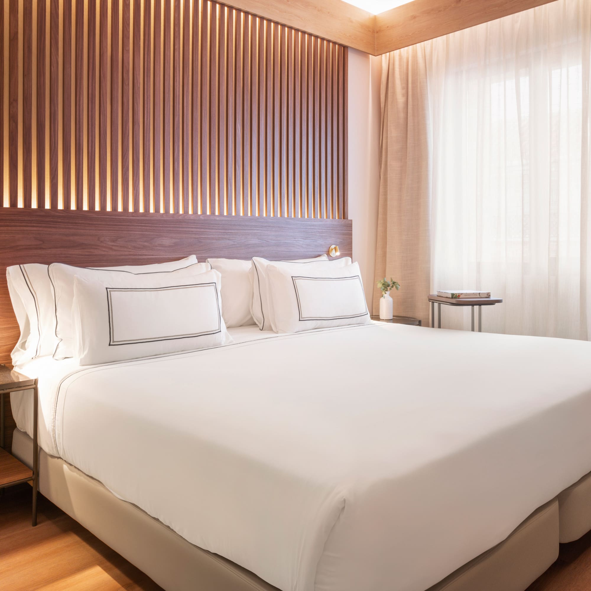 a bed with white sheets and a wood paneled wall