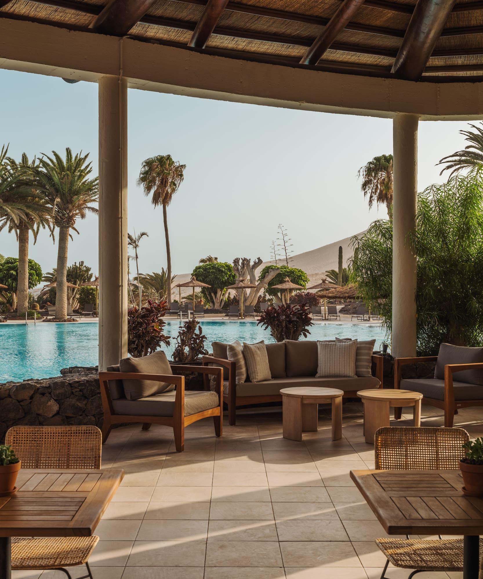 a patio with chairs and tables and a pool