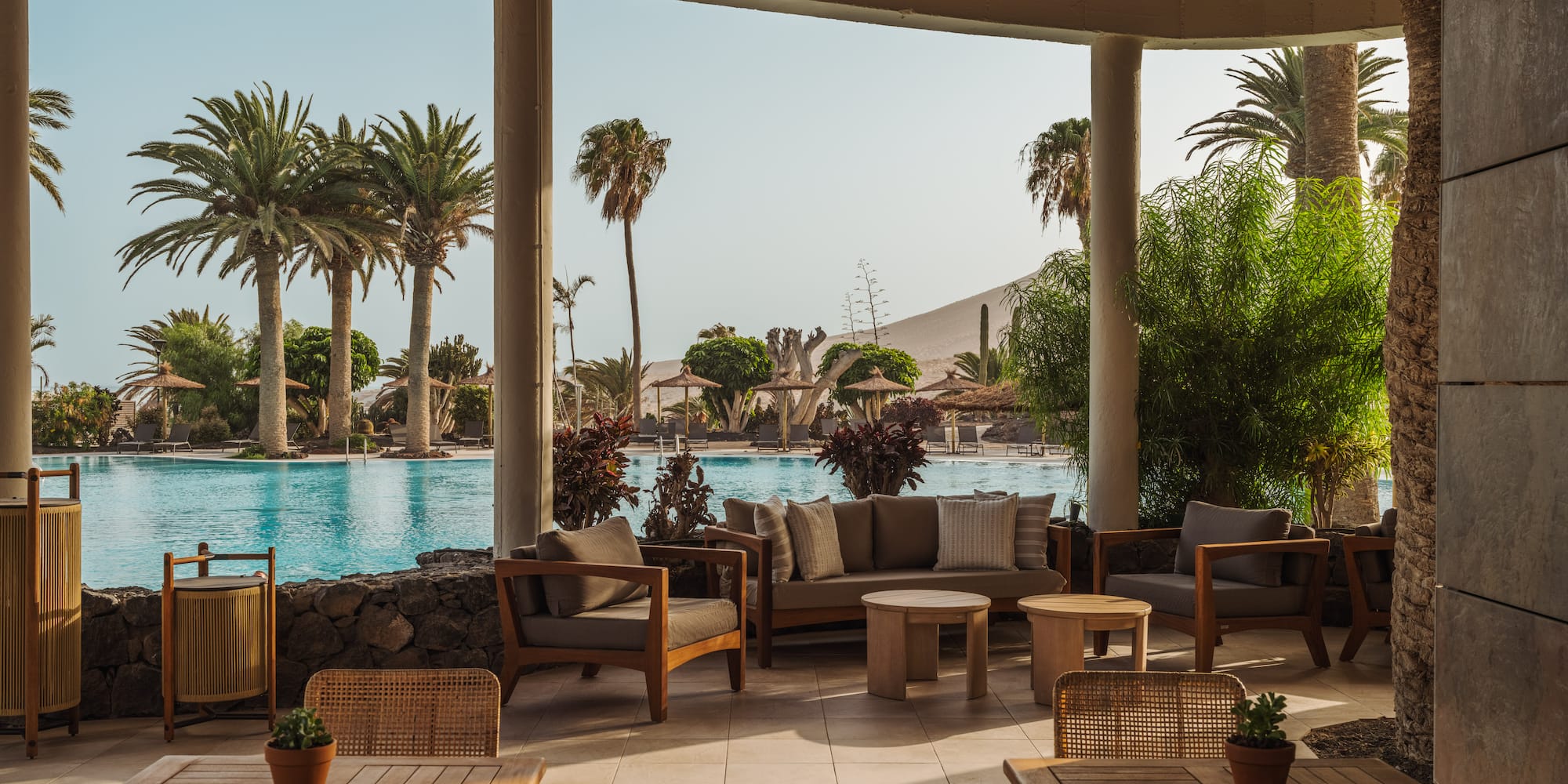 a patio with chairs and tables and a pool