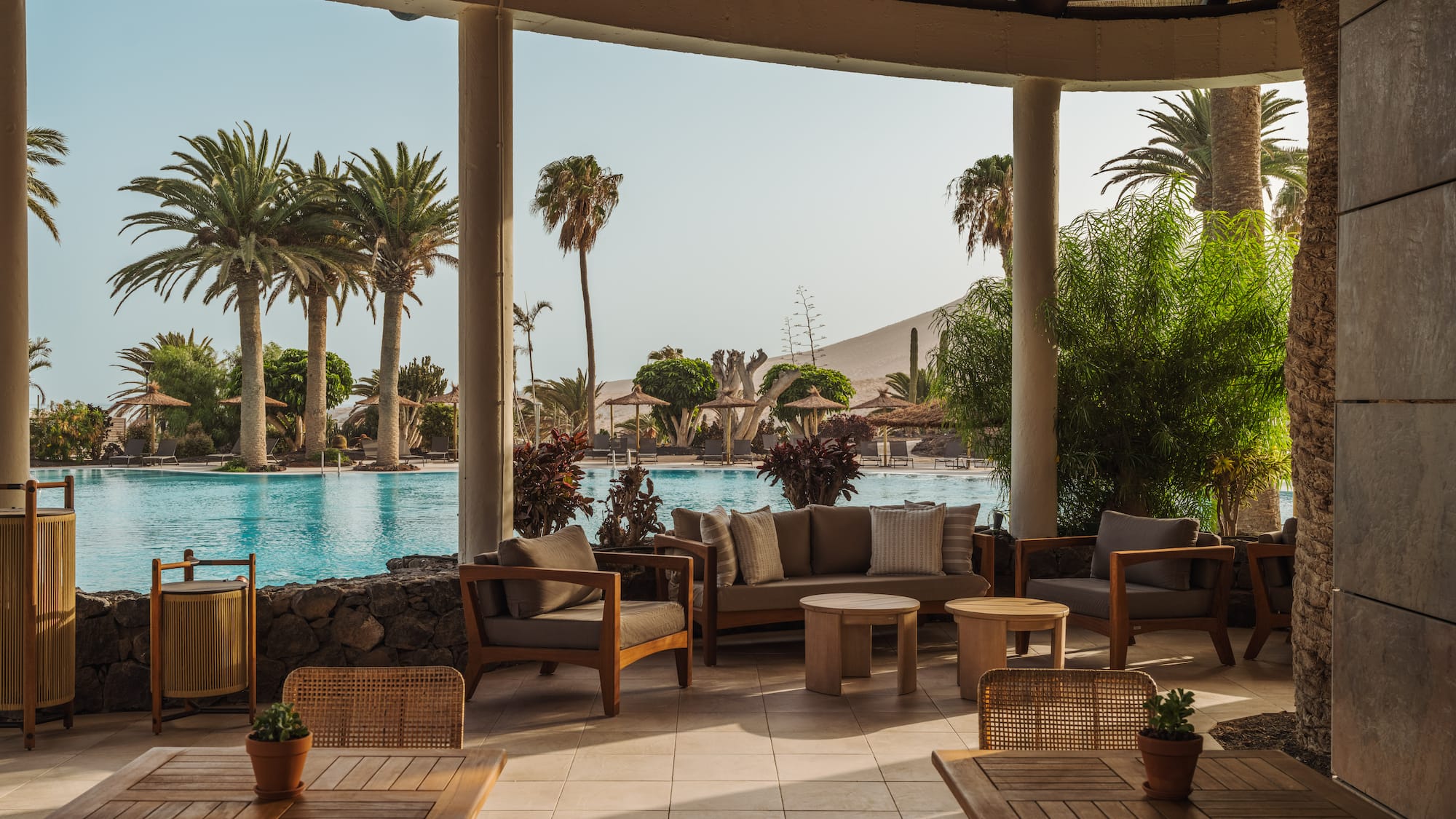 a patio with chairs and tables and a pool