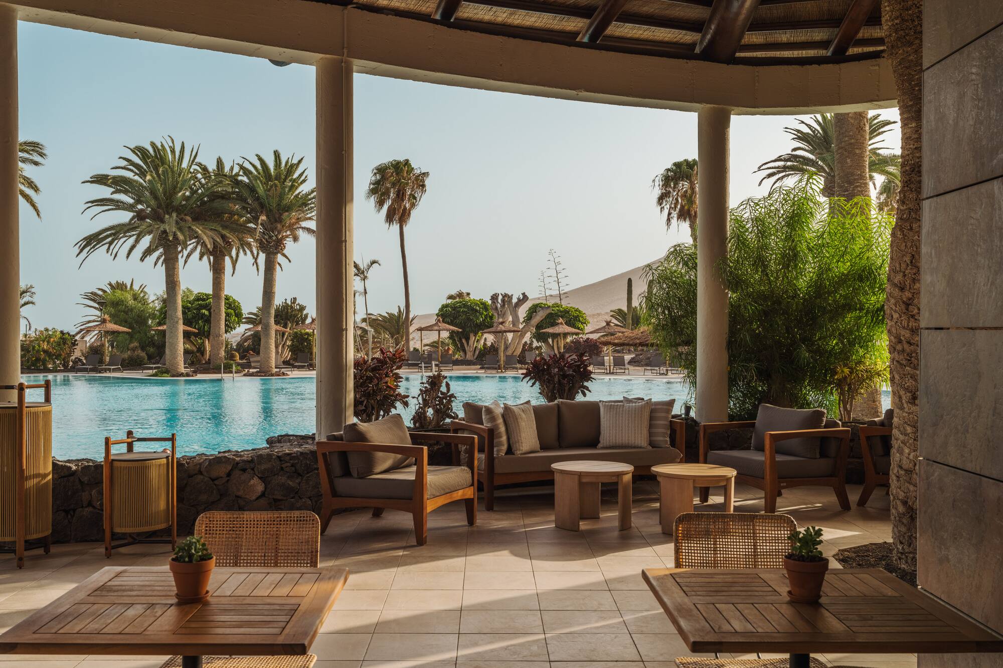 a patio with chairs and tables and a pool