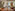 Elegant restaurant dining room, set tables, plush chairs, city view.