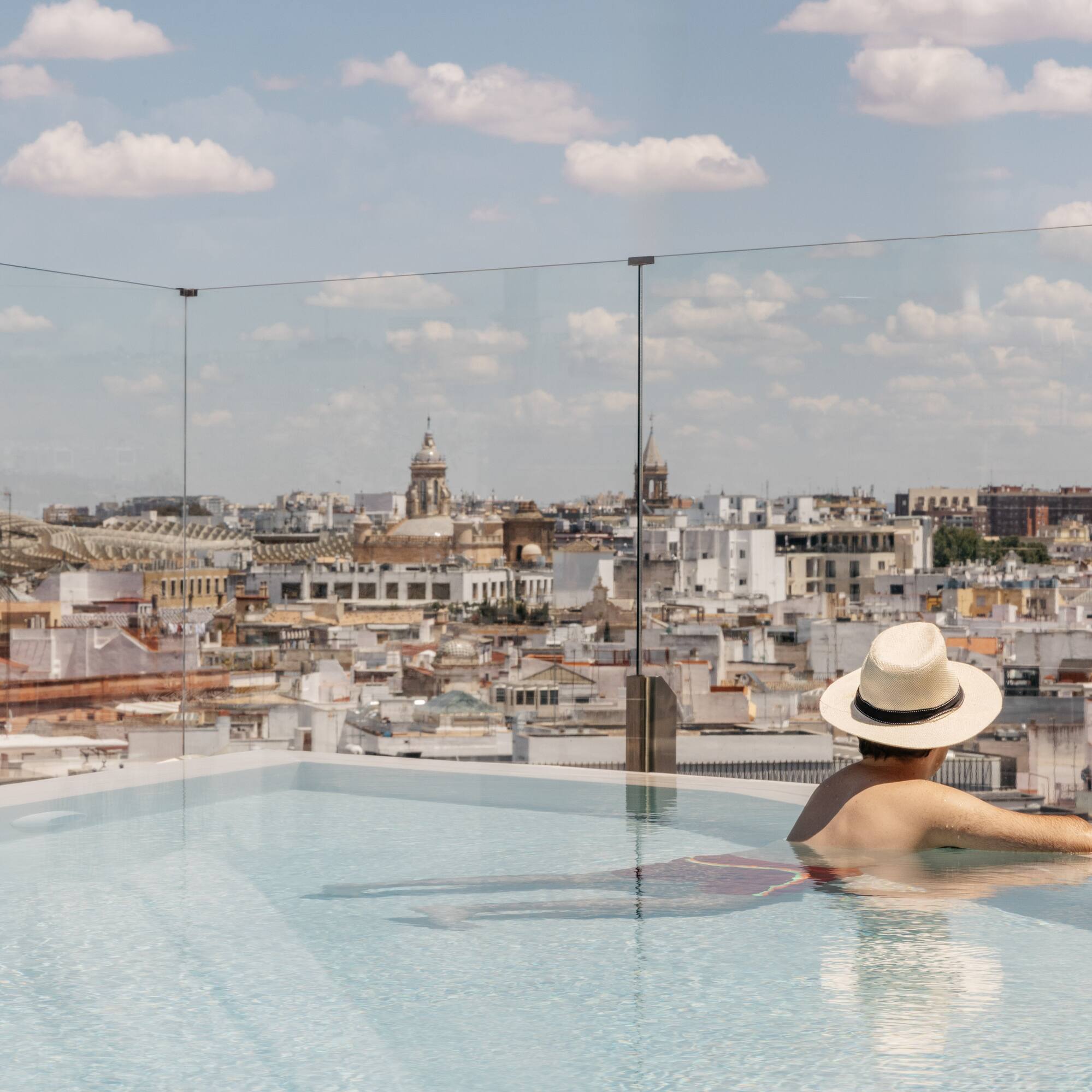 a person in a pool with a city in the background
