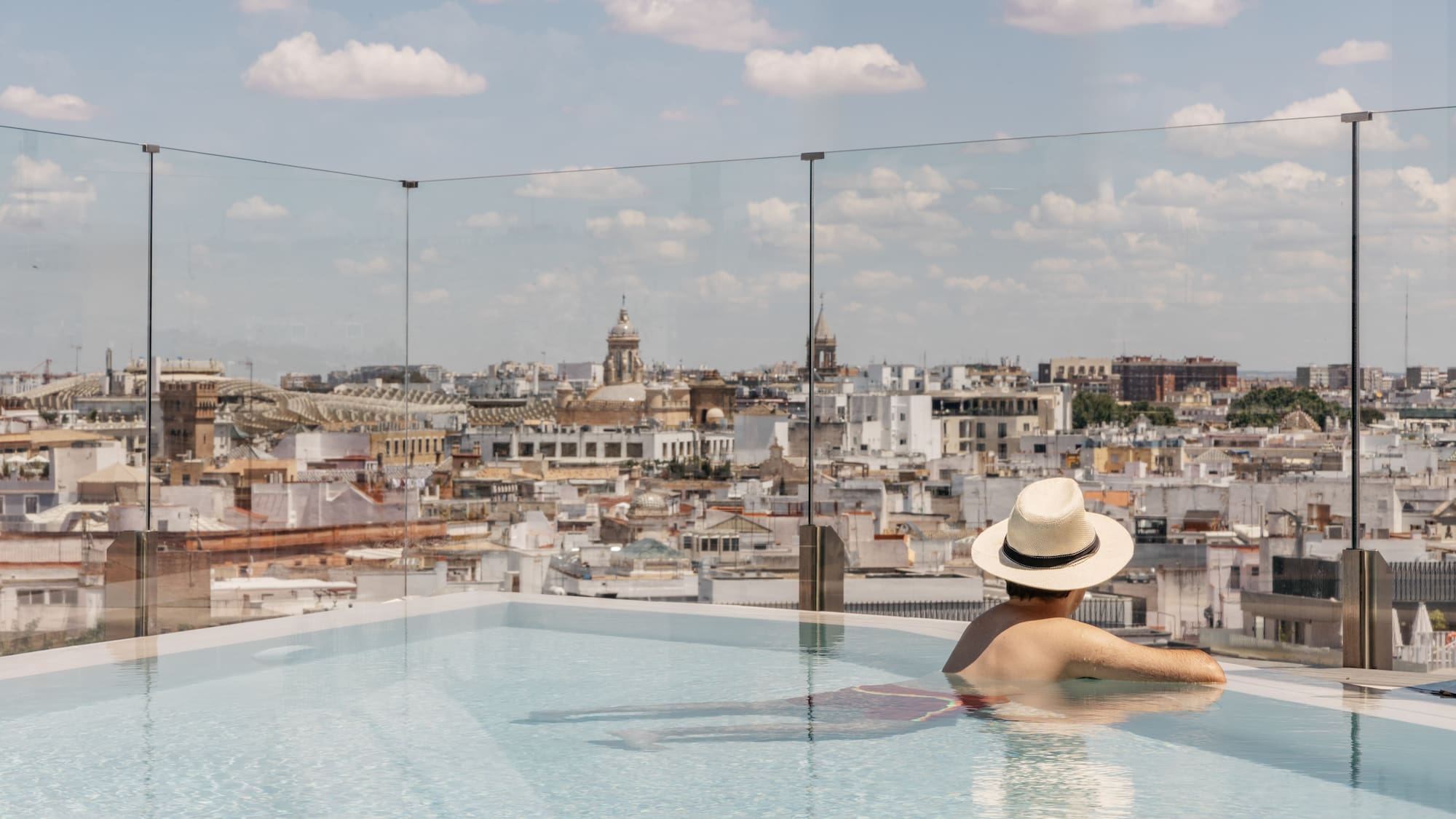 a person in a pool with a city in the background
