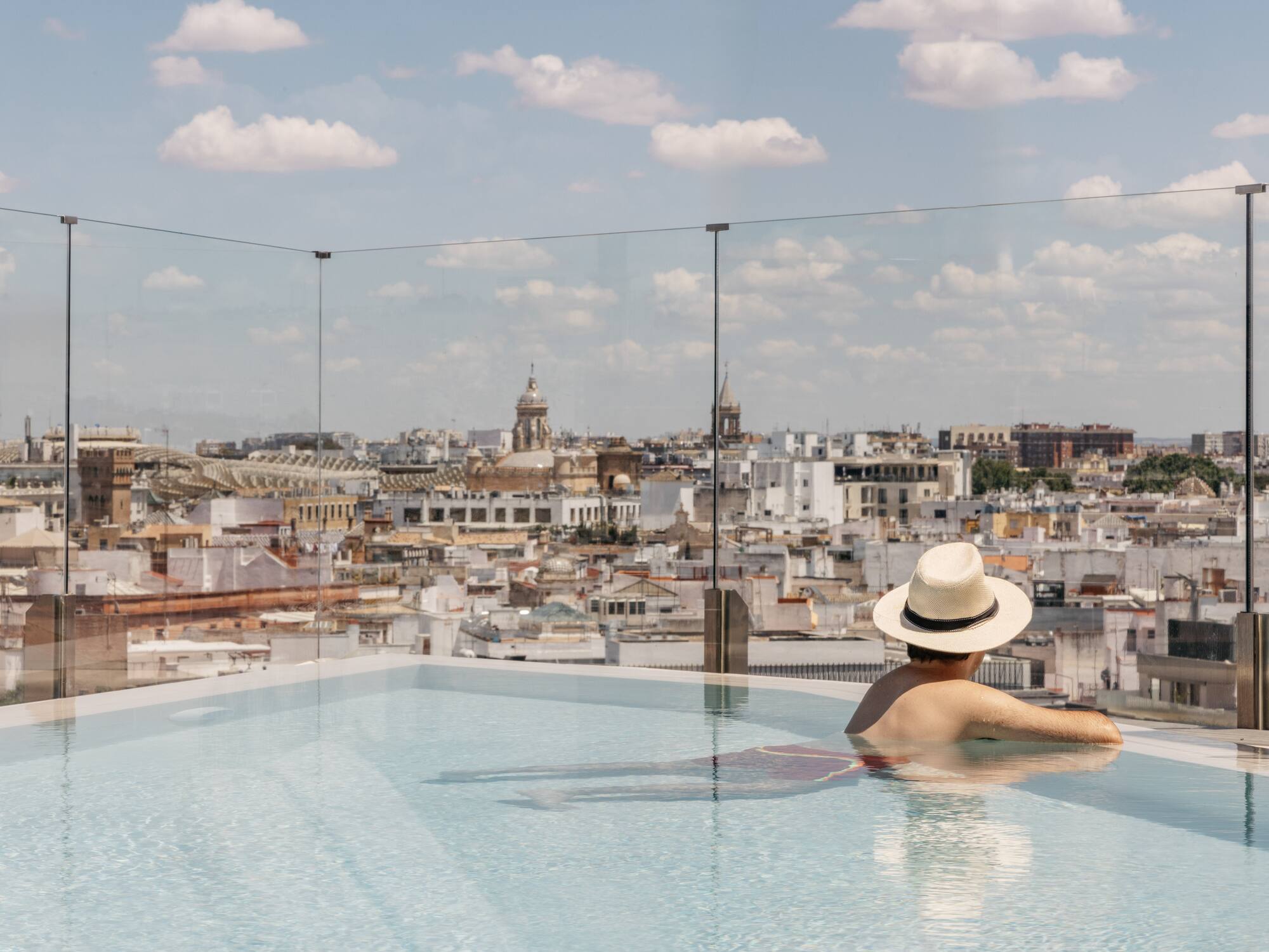 a person in a pool with a city in the background