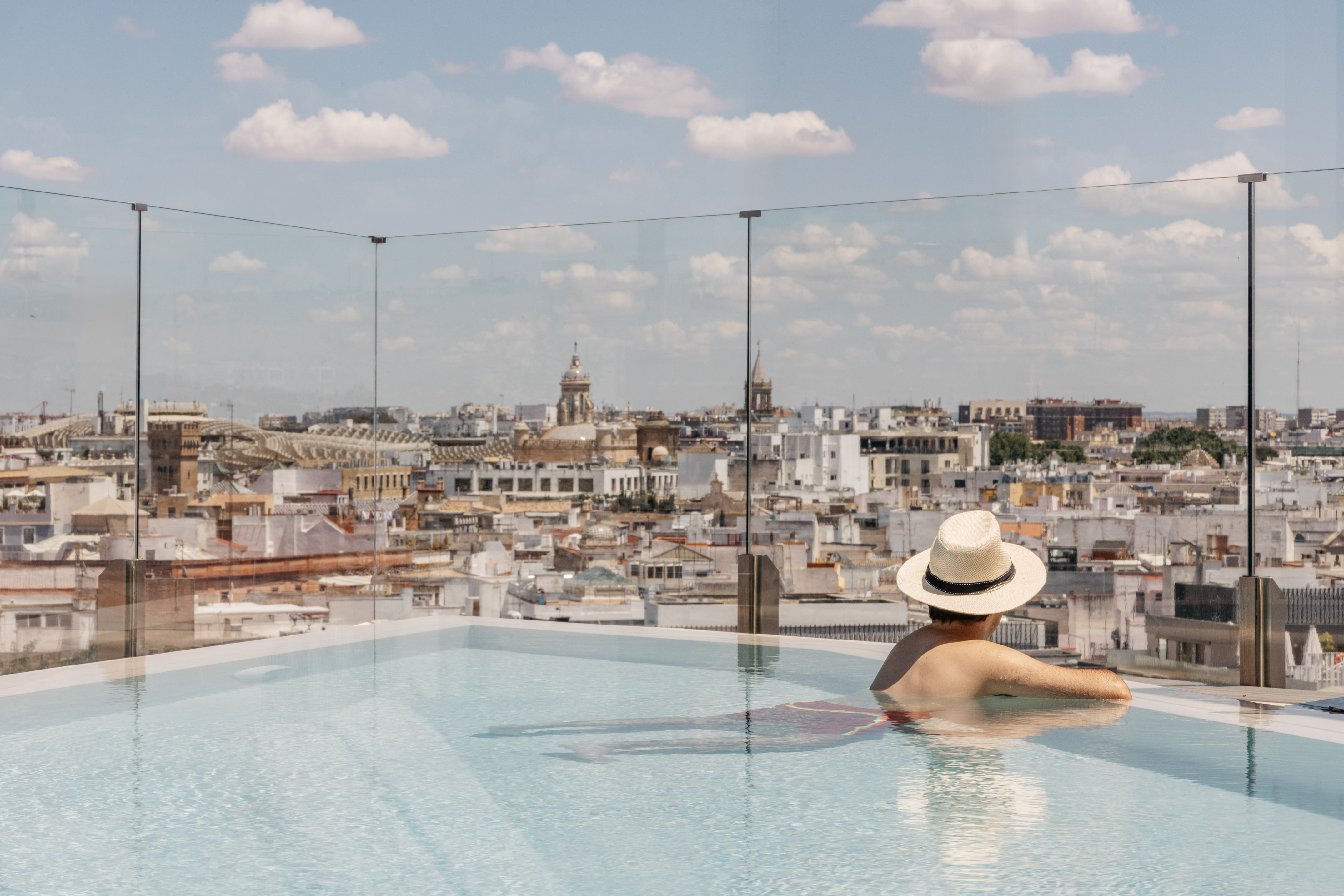 a person in a pool with a city in the background