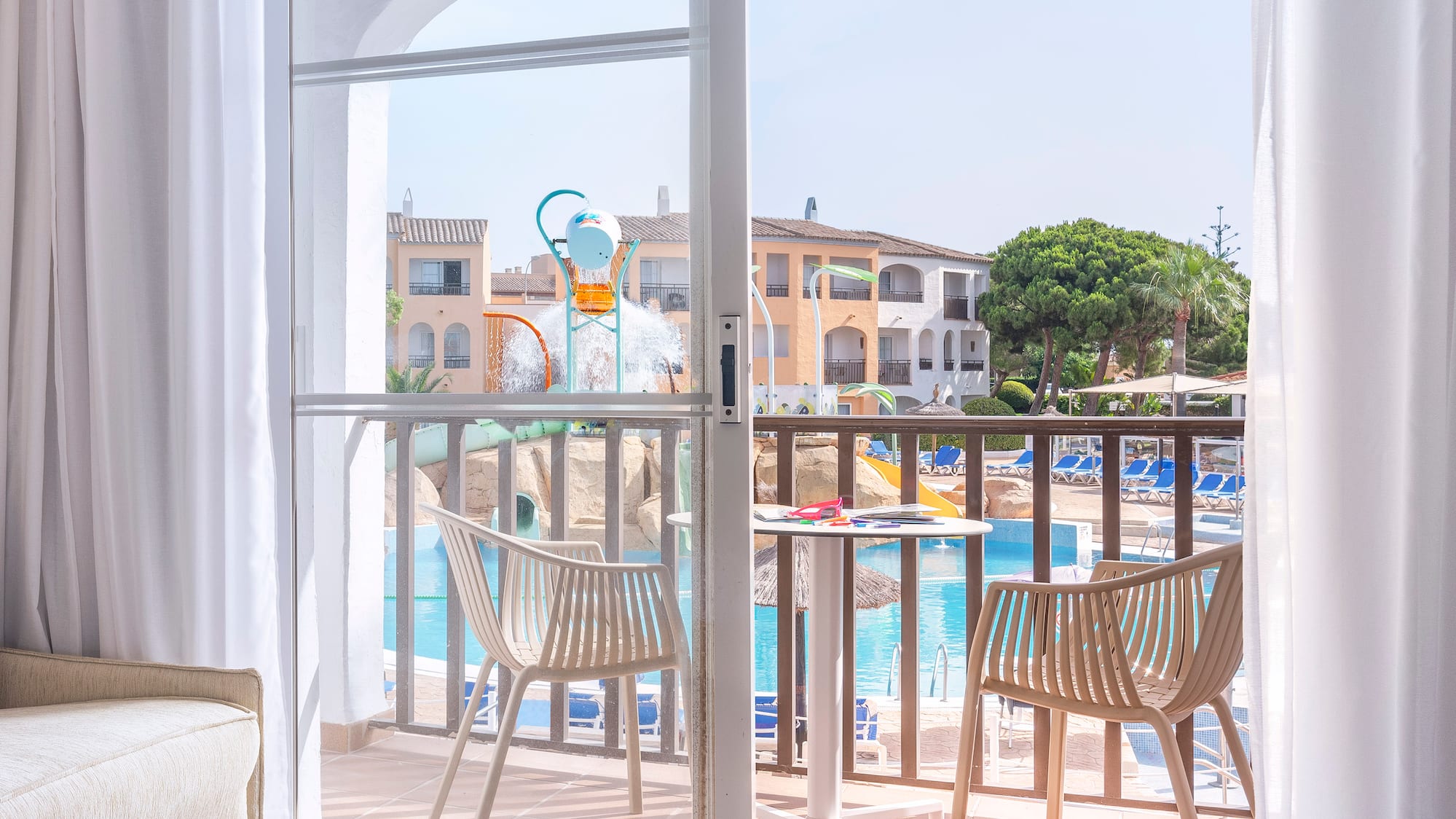 a sliding glass door to a room with a pool and chairs