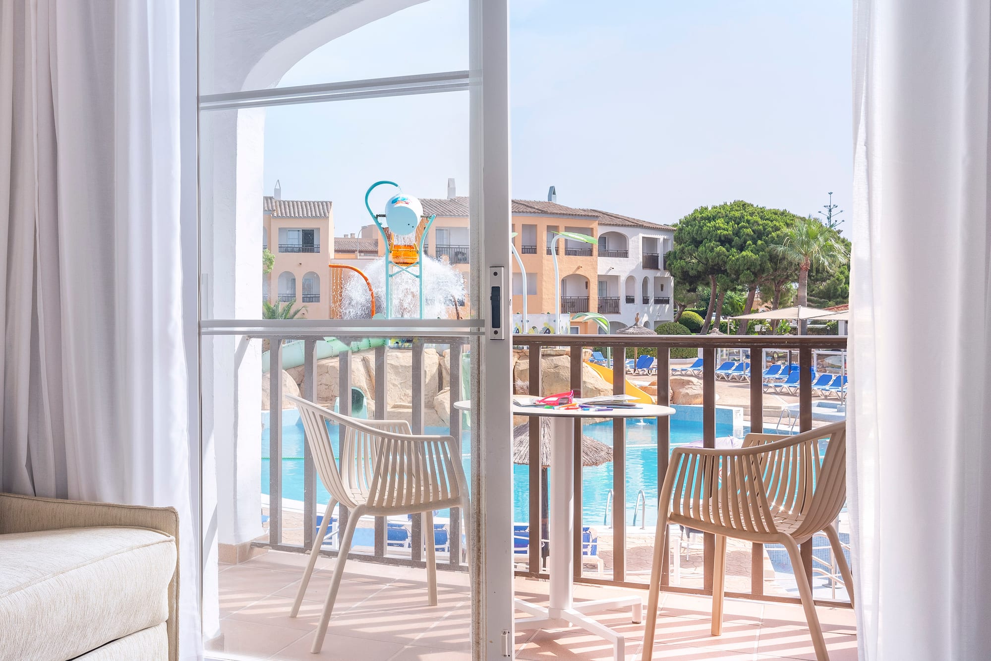 a sliding glass door to a room with a pool and chairs