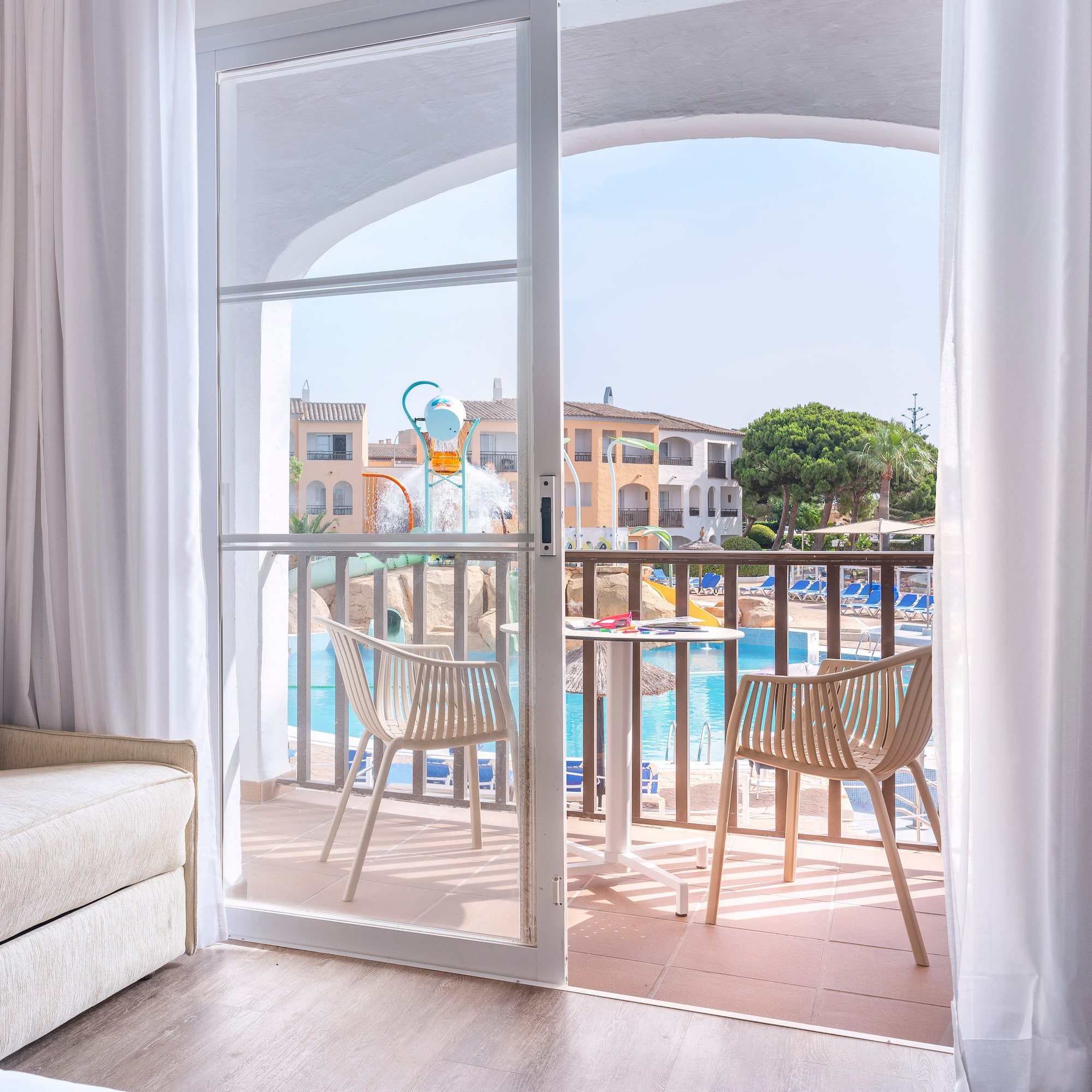 a sliding glass door to a room with a pool and chairs