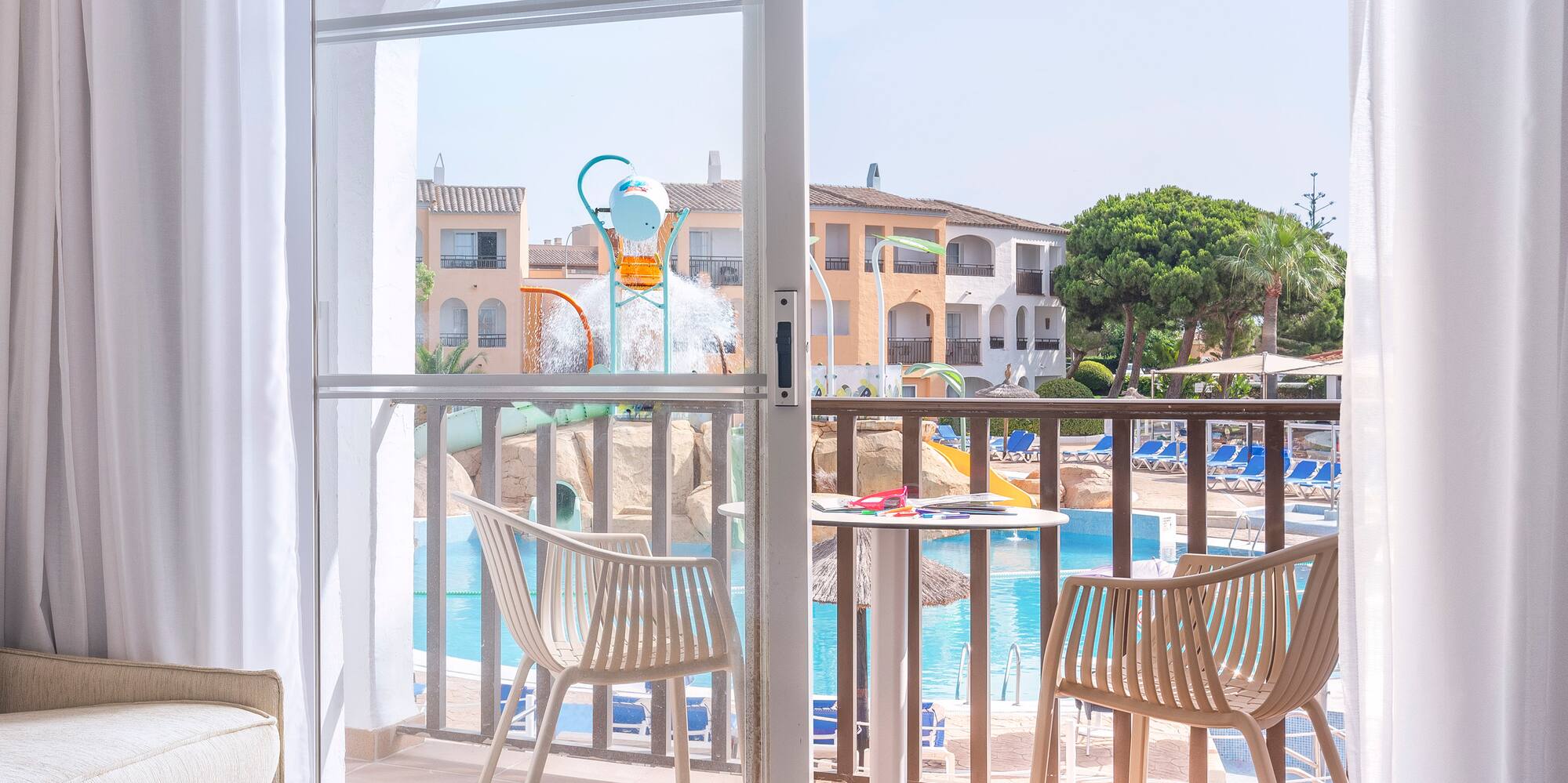 a sliding glass door to a room with a pool and chairs