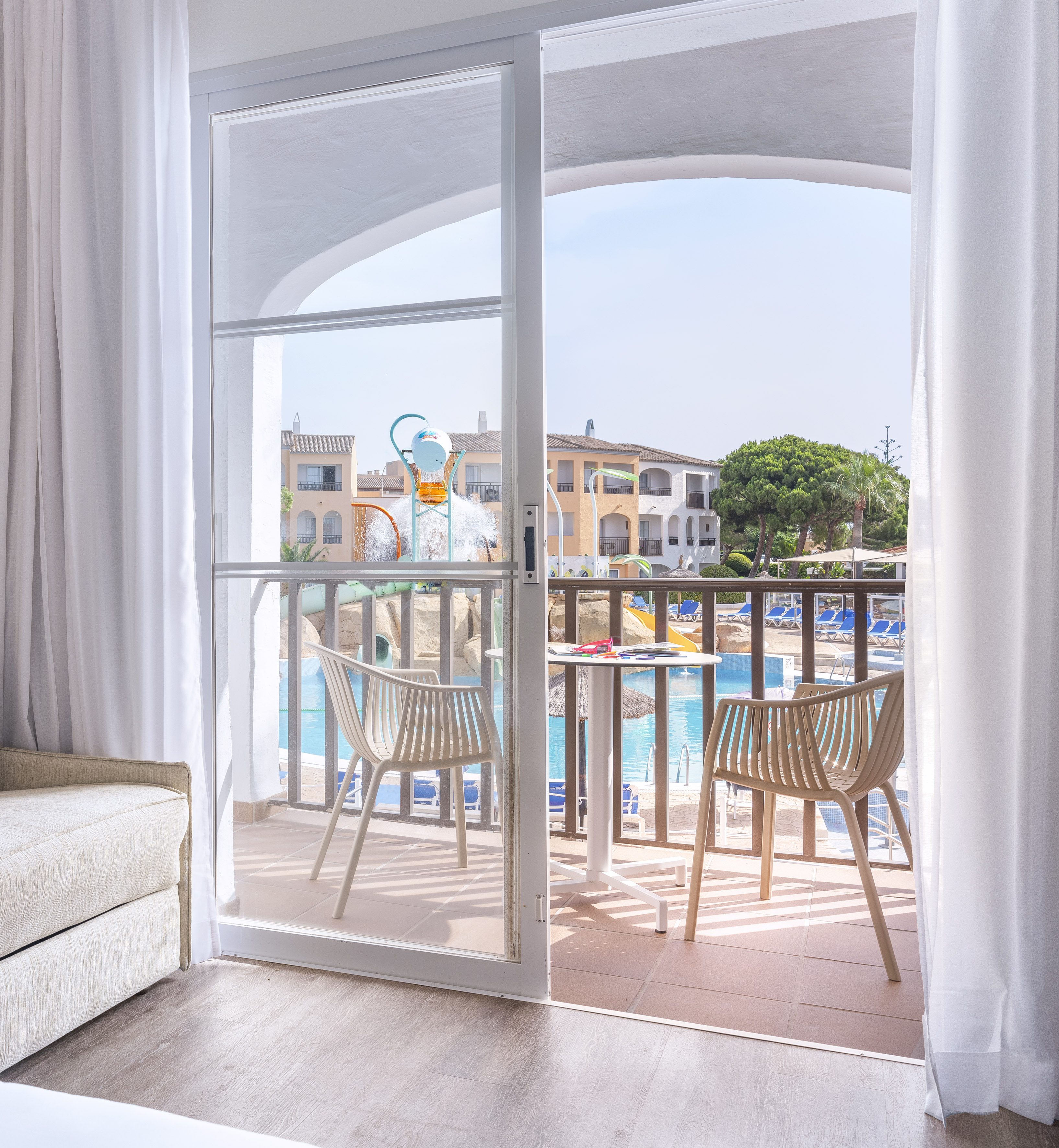a sliding glass door to a room with a pool and chairs