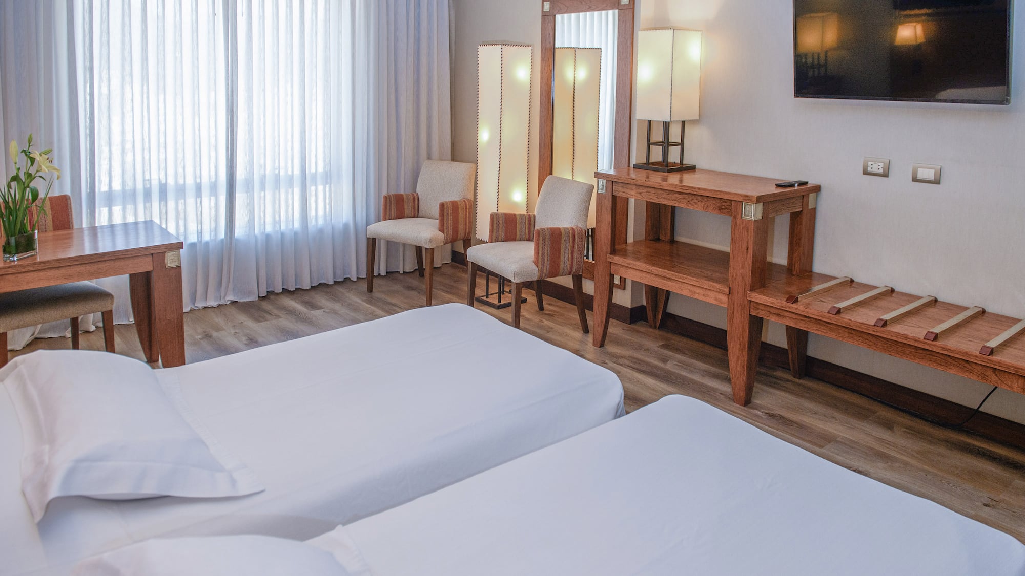 a room with two beds and a mirror