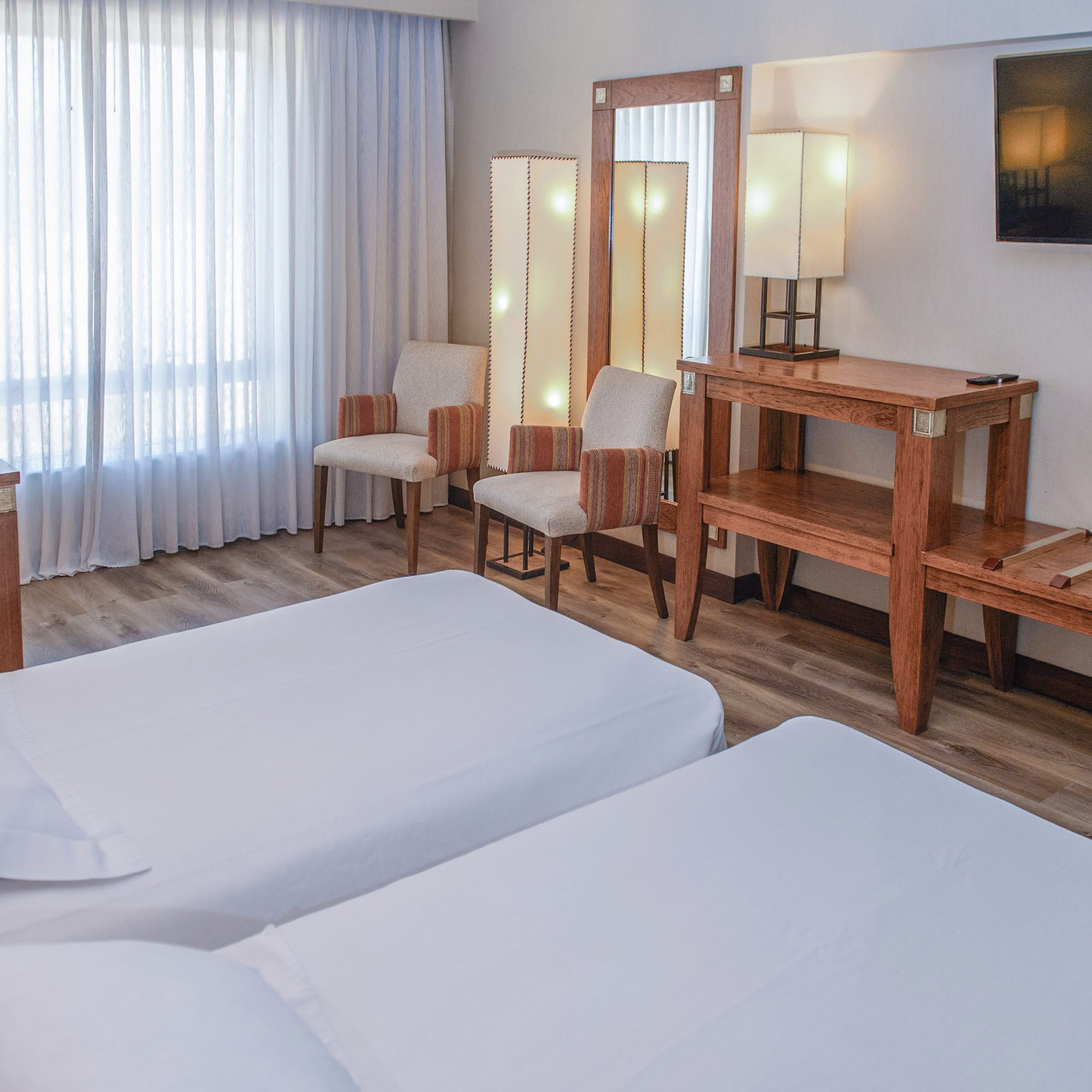 a room with two beds and a mirror