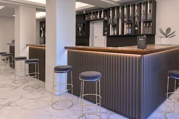 a bar with stools and bottles