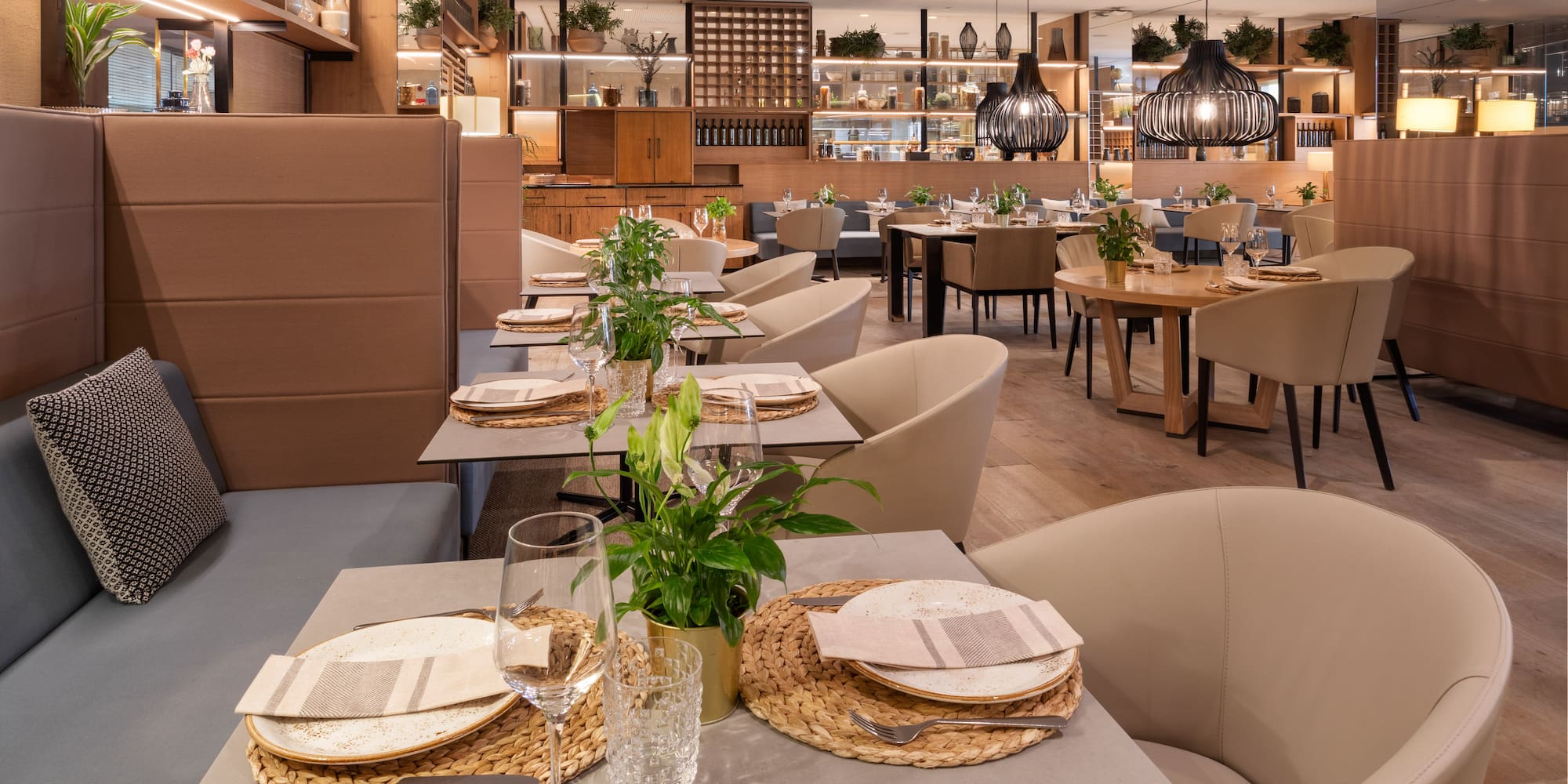 Modern restaurant dining room with set tables, cozy seating, and elegant decor.
