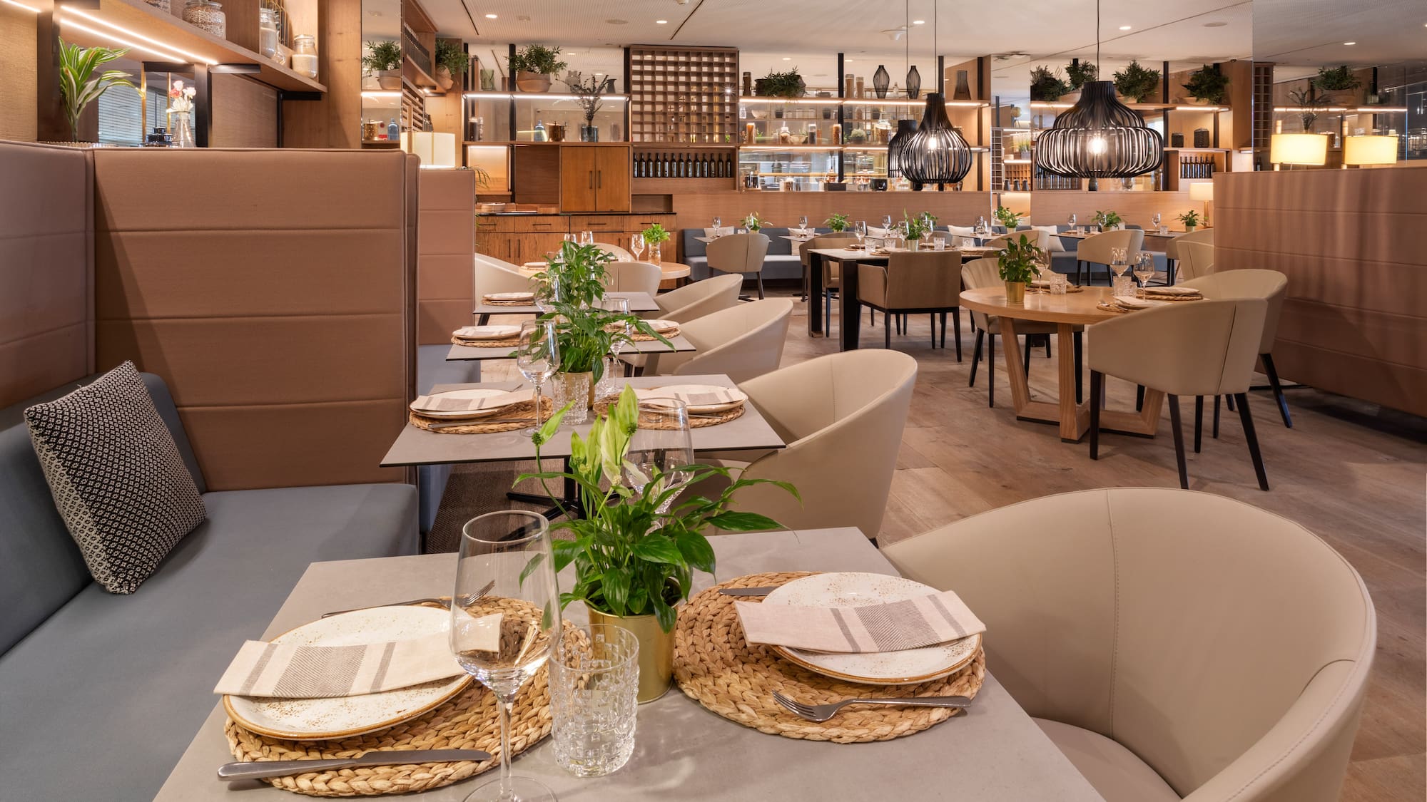 Modern restaurant dining room with set tables, cozy seating, and elegant decor.