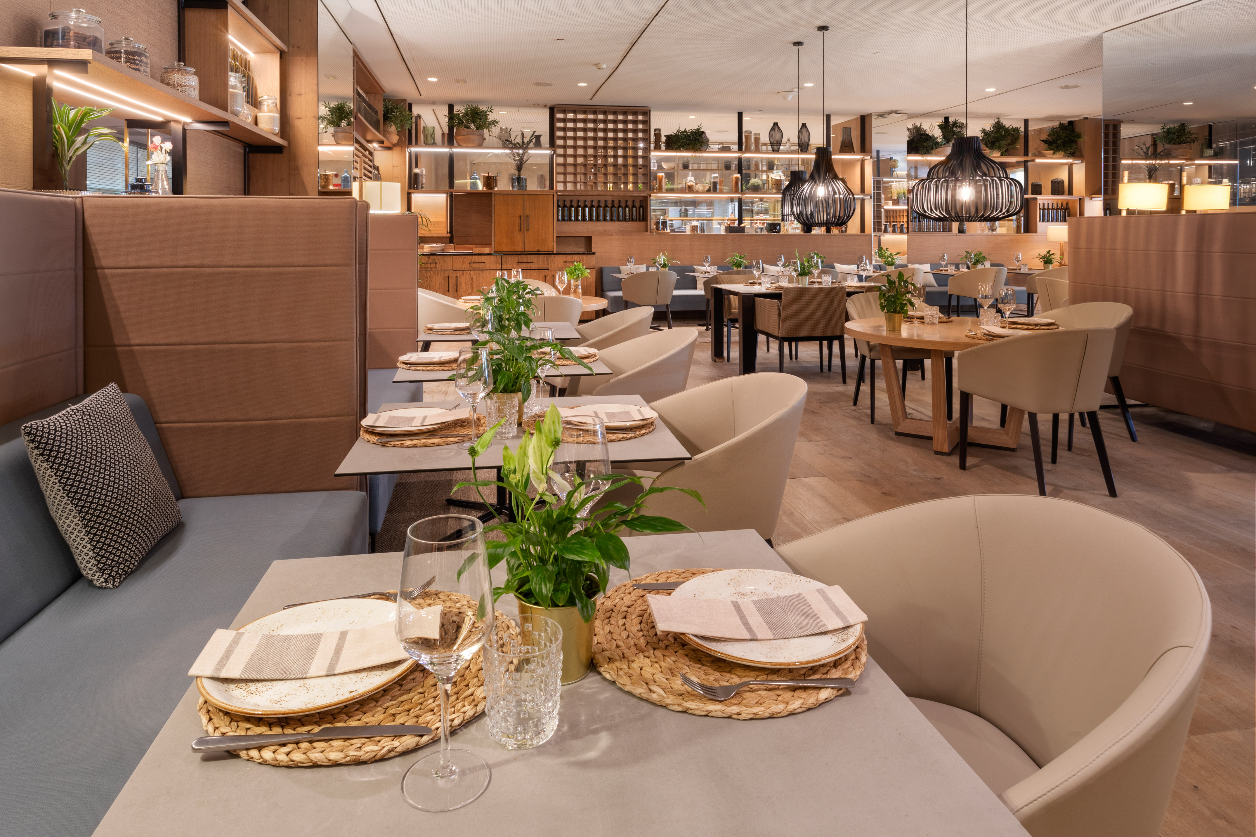 Modern restaurant dining room with set tables, cozy seating, and elegant decor.