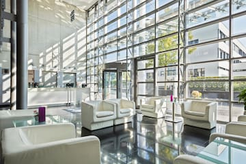 a room with white furniture and glass walls