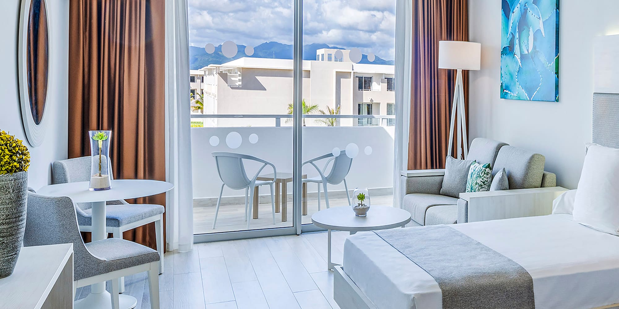 a room with two beds and a table and chairs