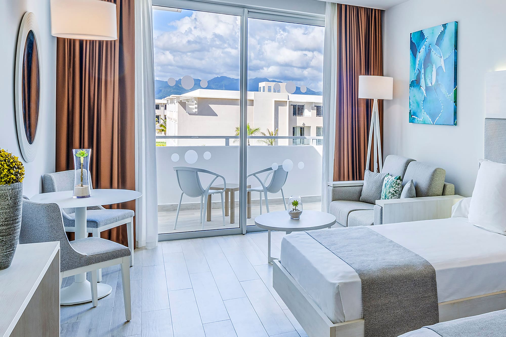 a room with two beds and a table and chairs