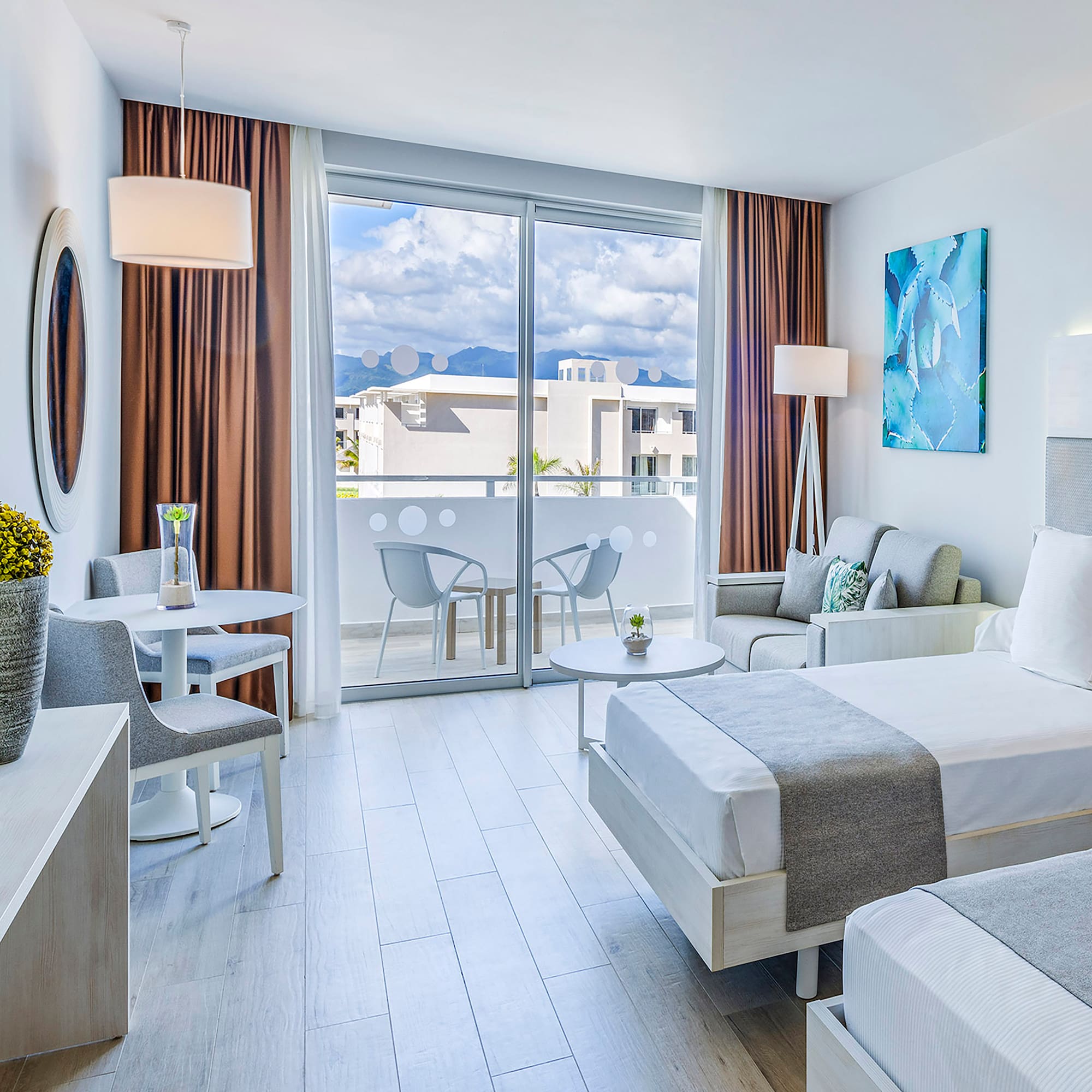 a room with two beds and a table and chairs