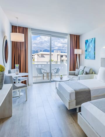 a room with two beds and a table and chairs