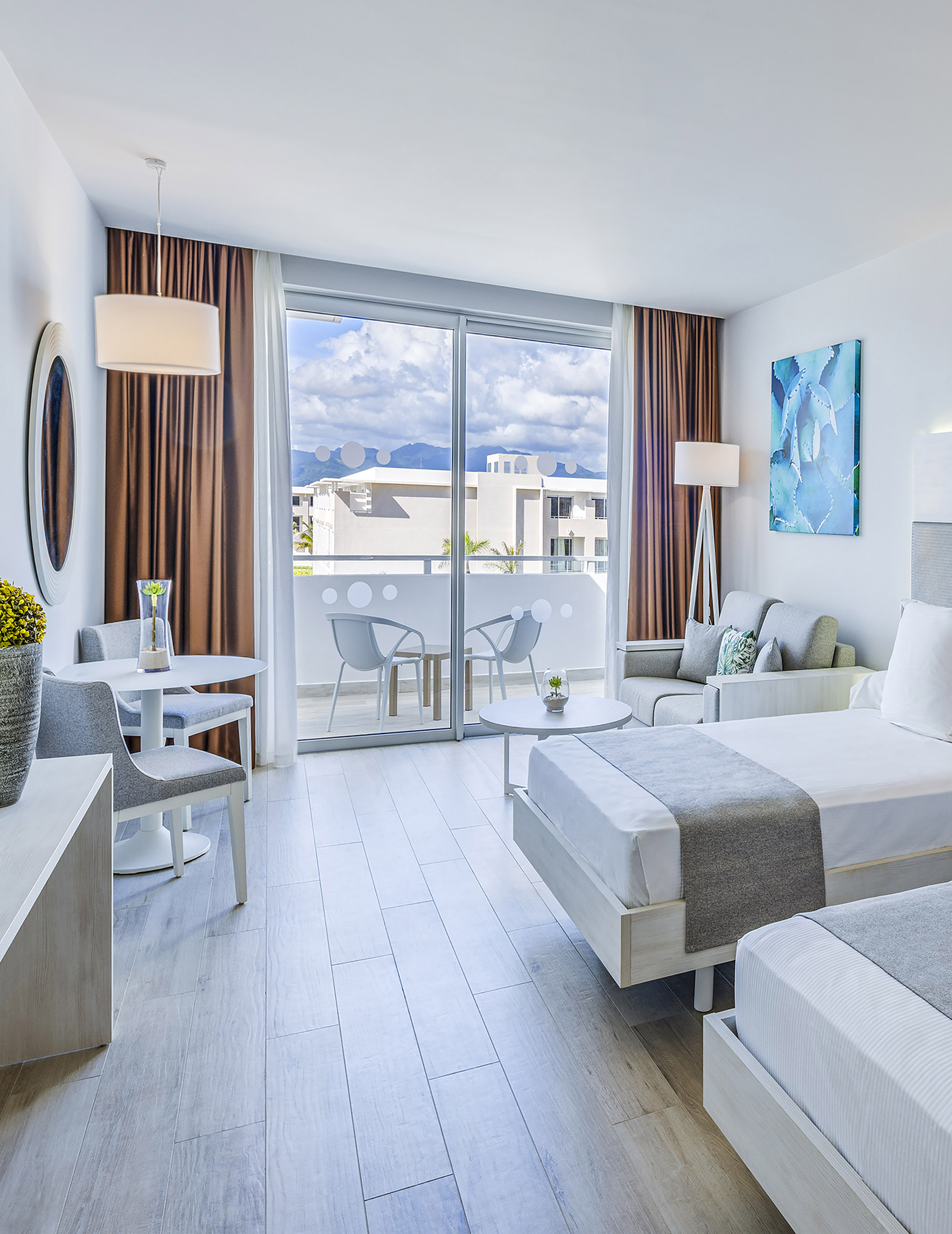 a room with two beds and a table and chairs