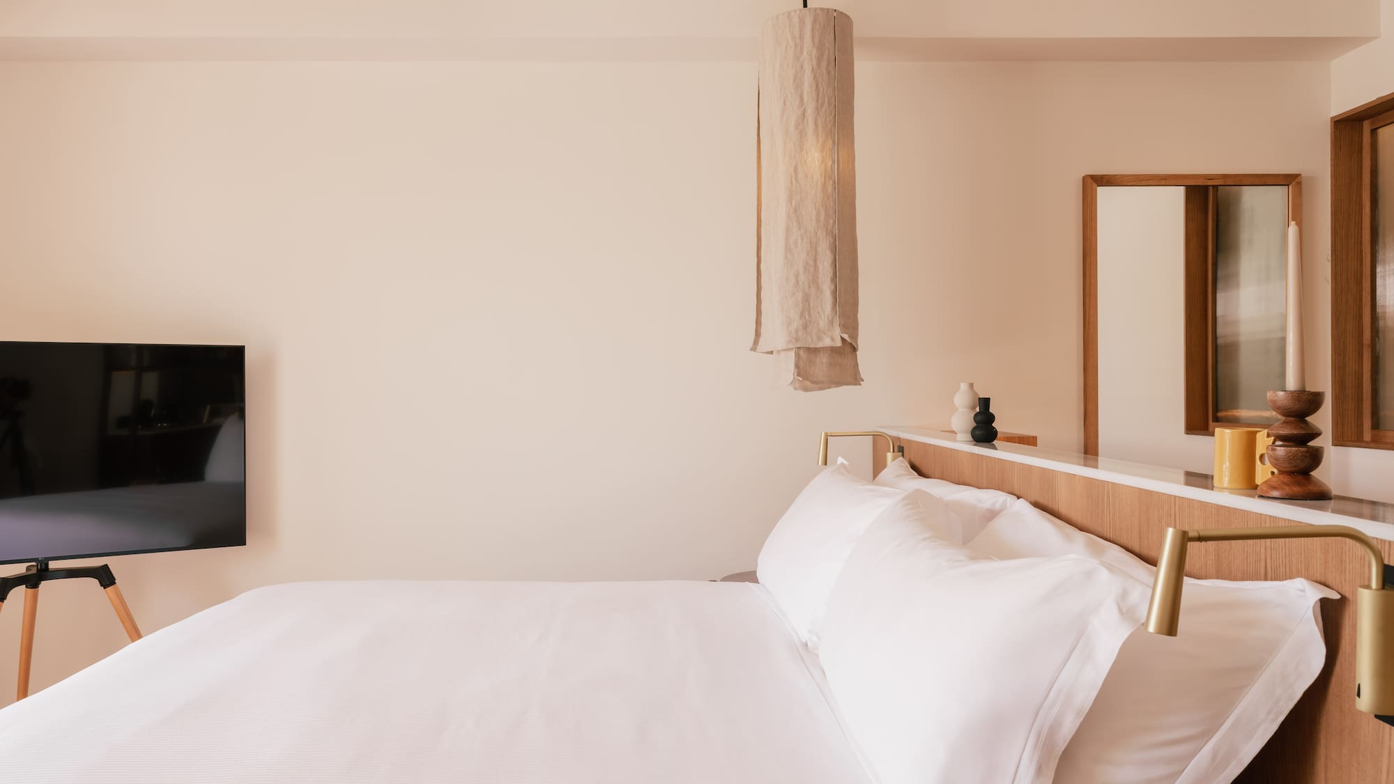 a bed with white sheets and a mirror