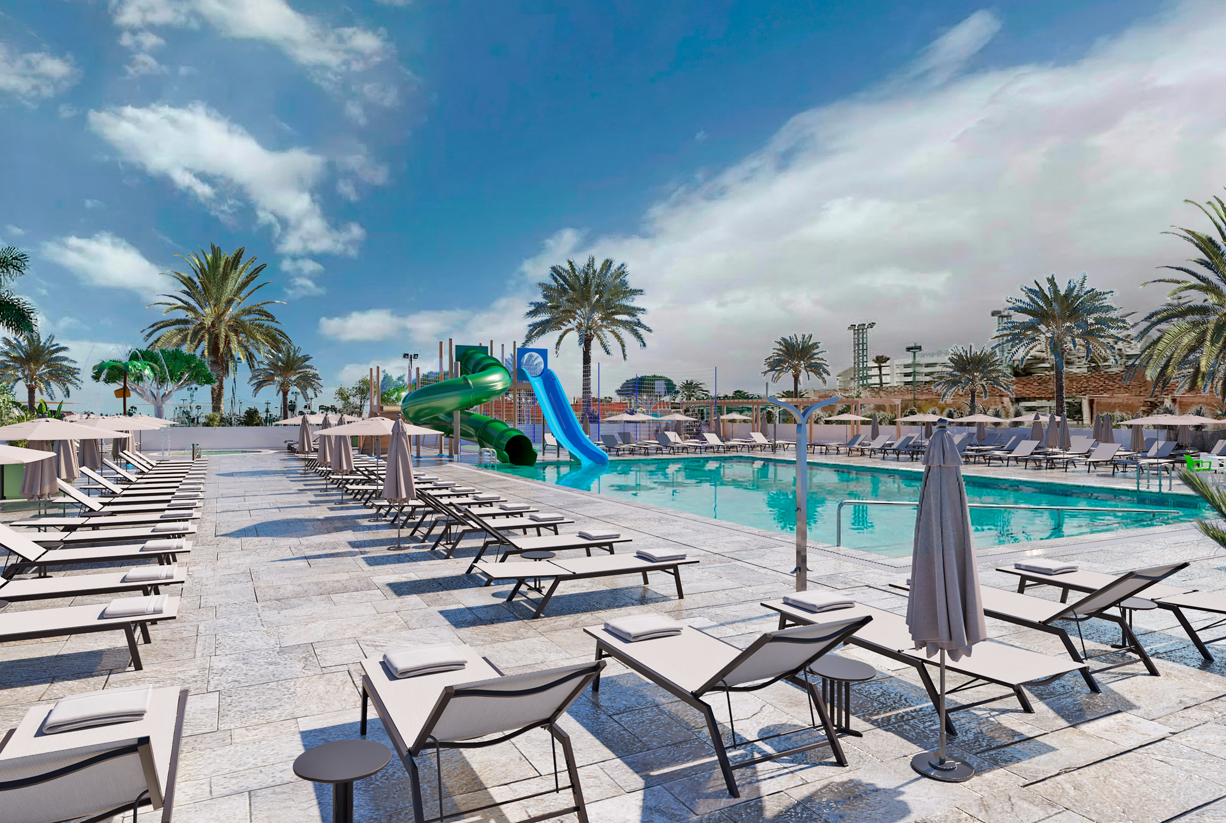 Resort swimming pool with water slides, sun loungers, and palm trees.
