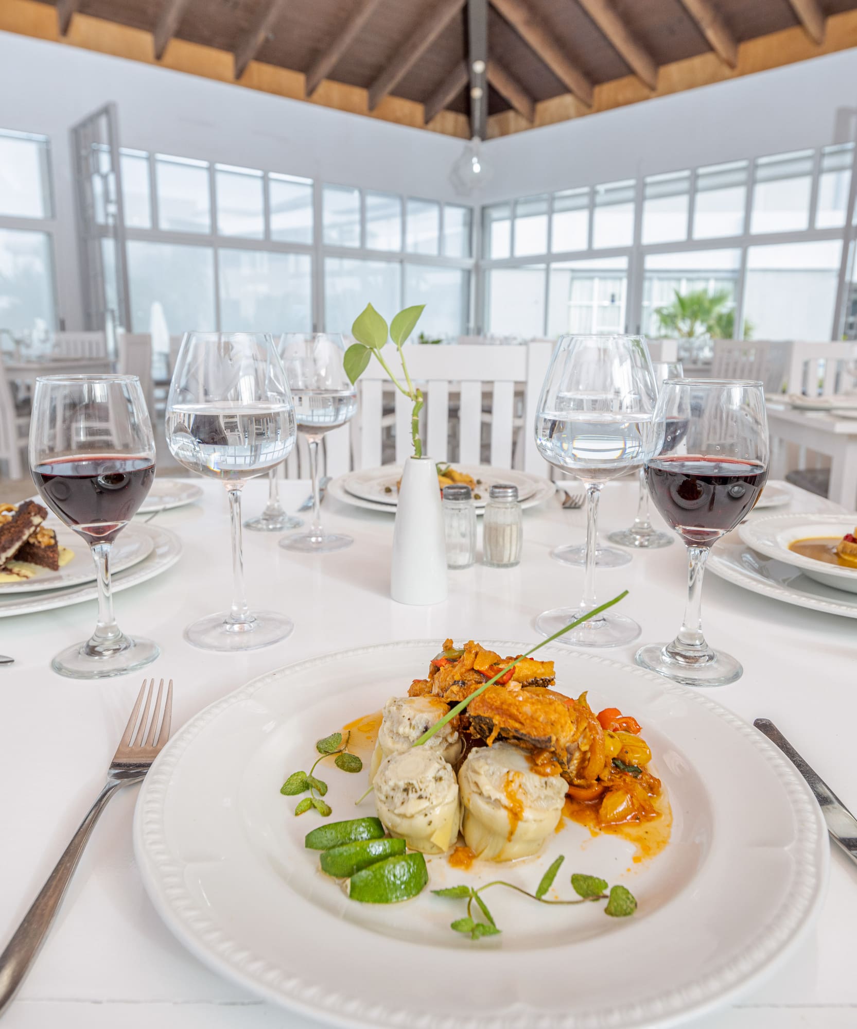 a table with plates of food and glasses of wine