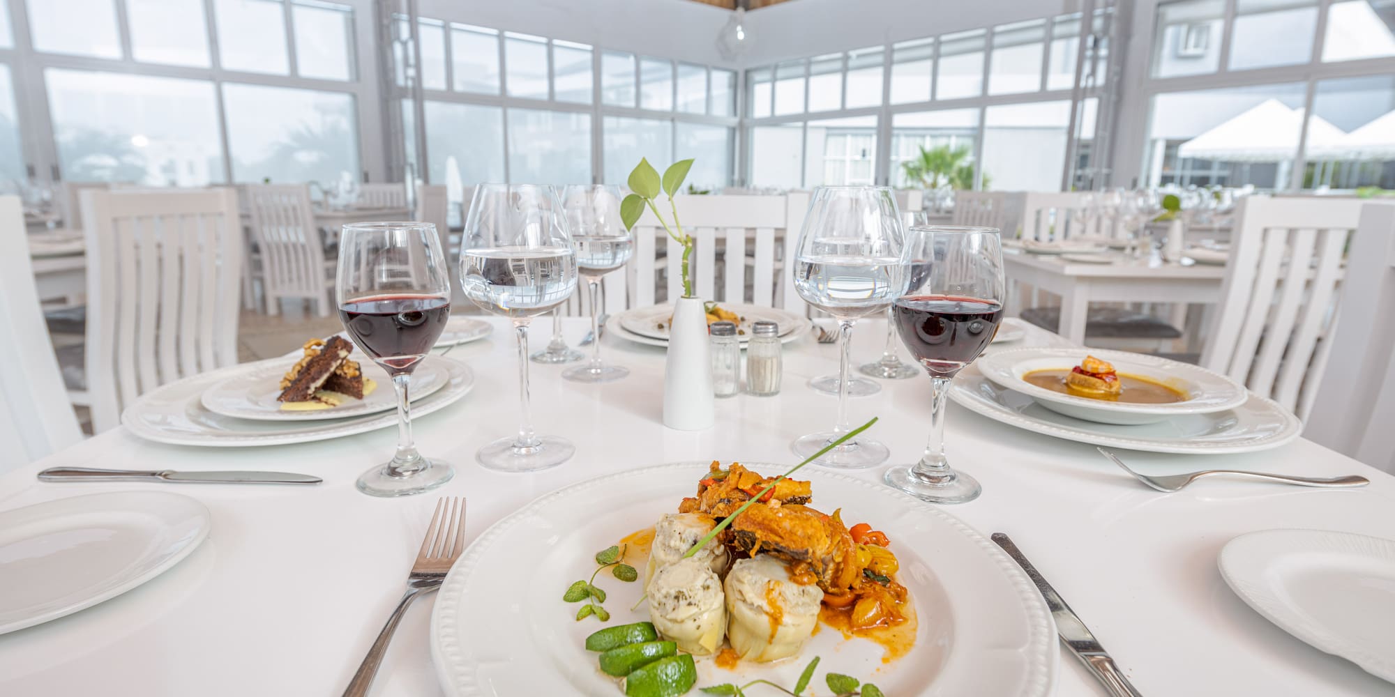 a table with plates of food and glasses of wine