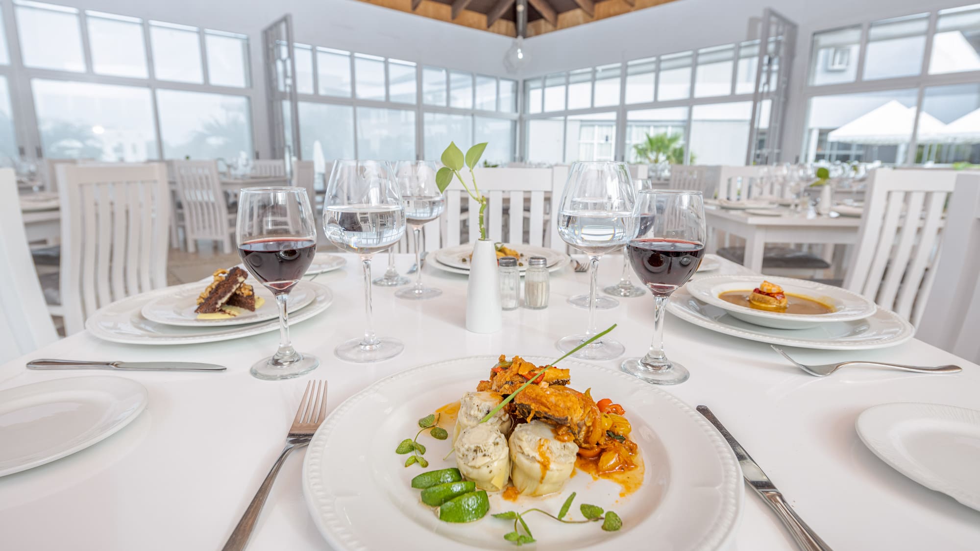 a table with plates of food and glasses of wine