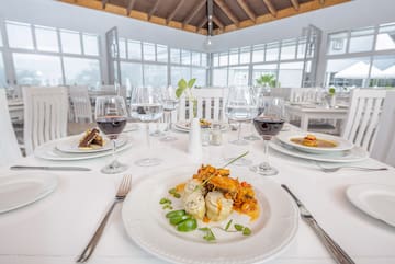 a table with plates of food and glasses of wine