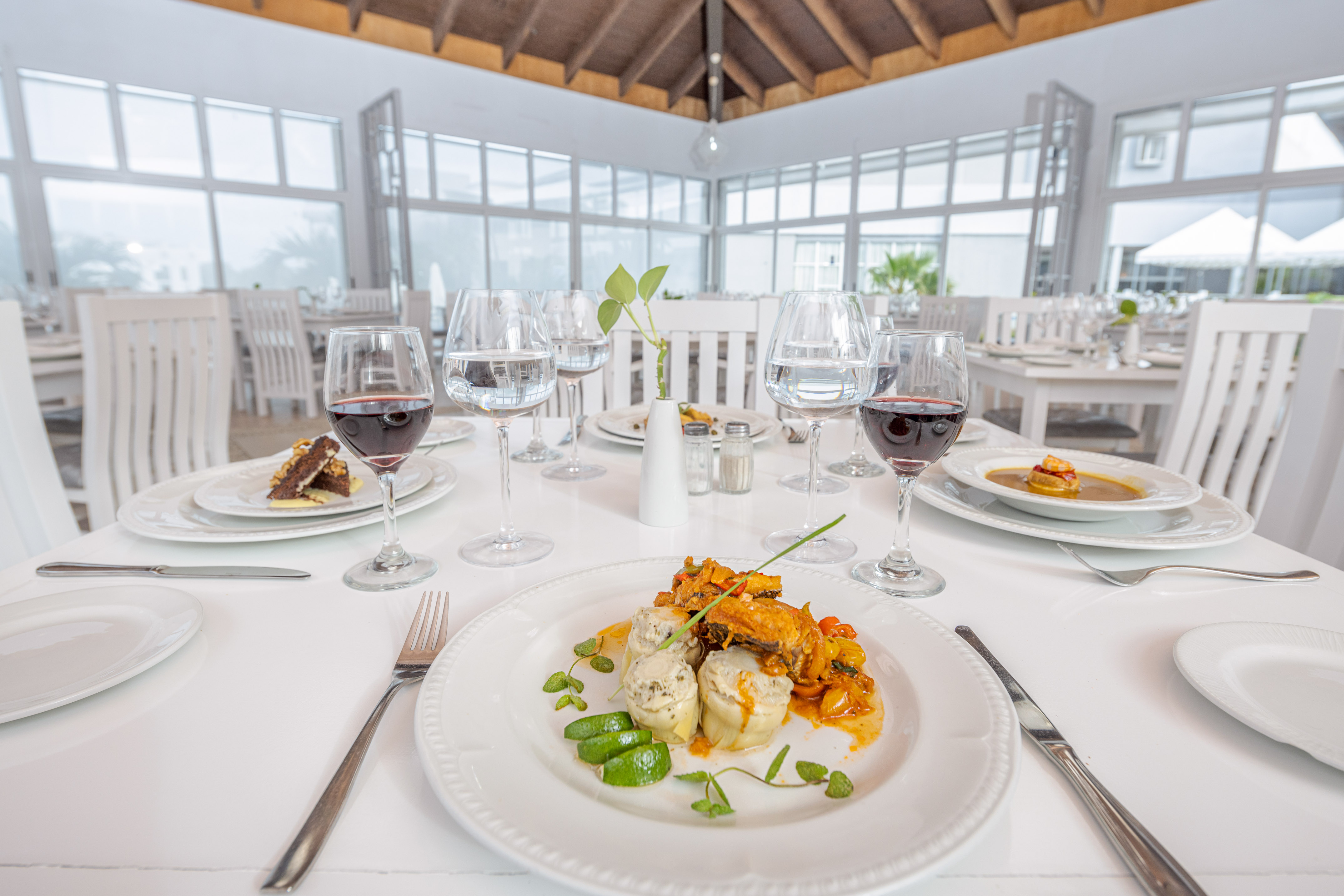 a table with plates of food and glasses of wine