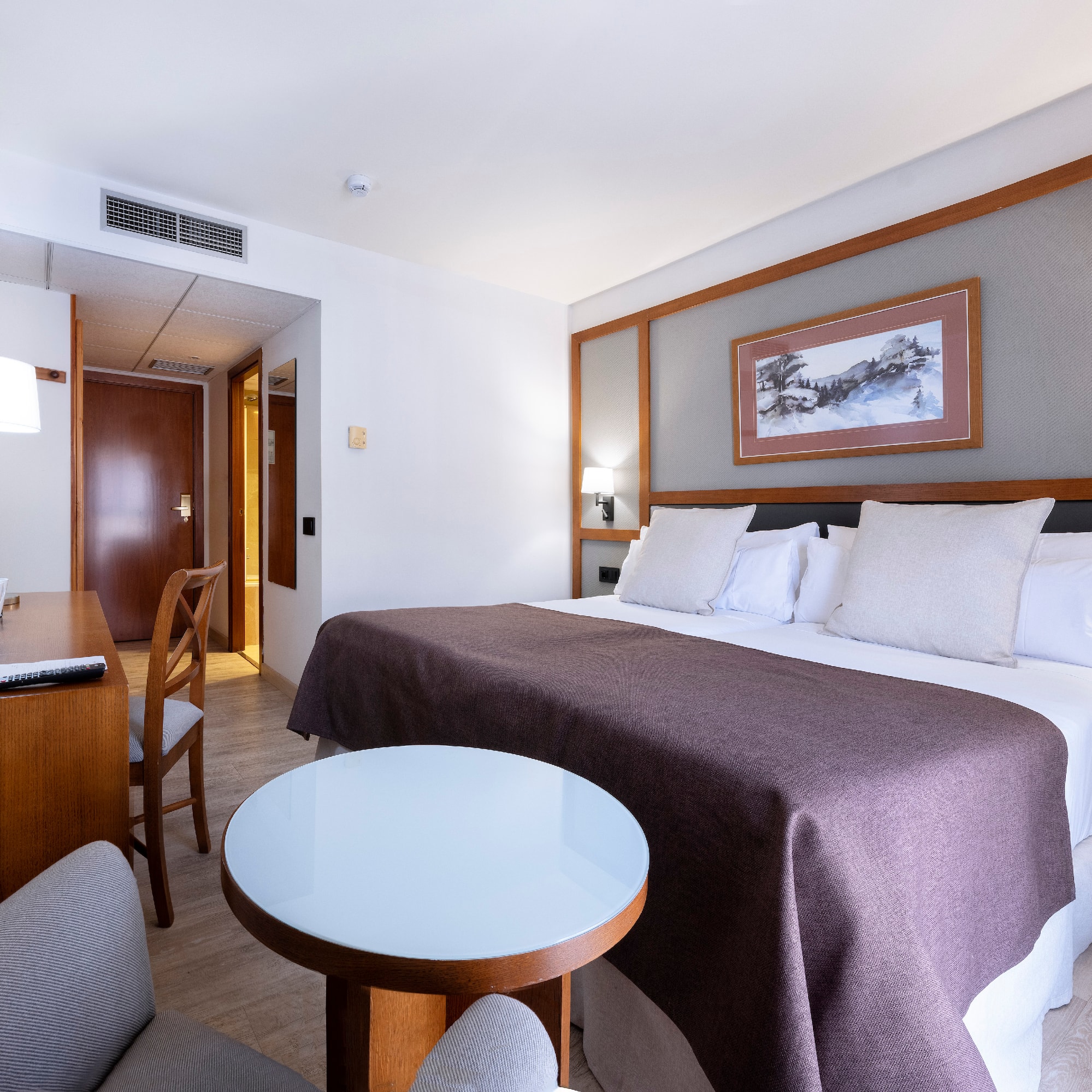 a room with a bed and chairs