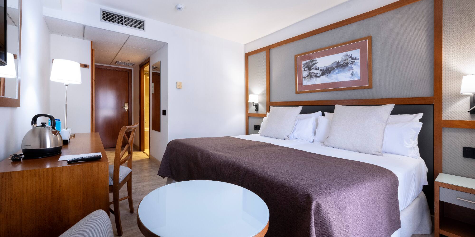 a room with a bed and chairs