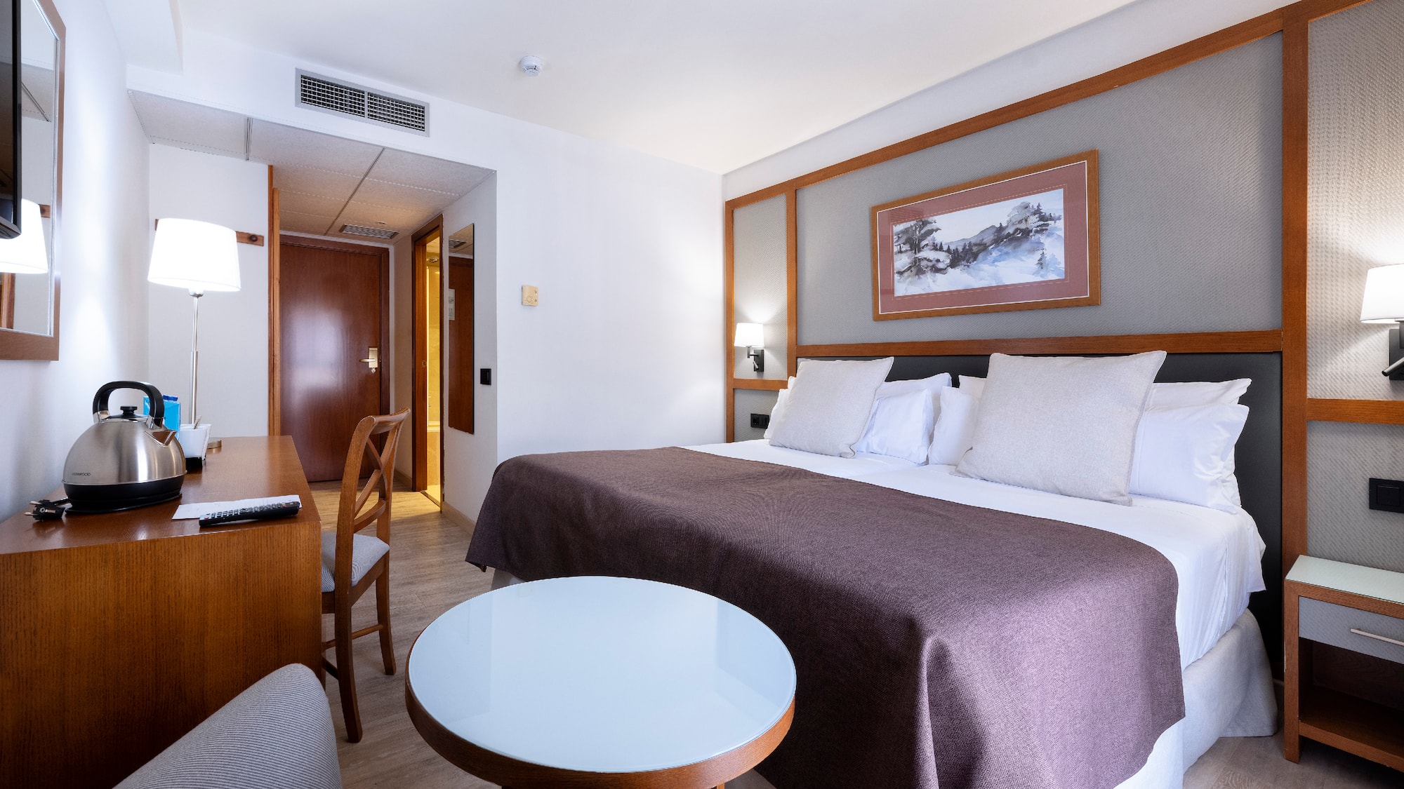 a room with a bed and chairs