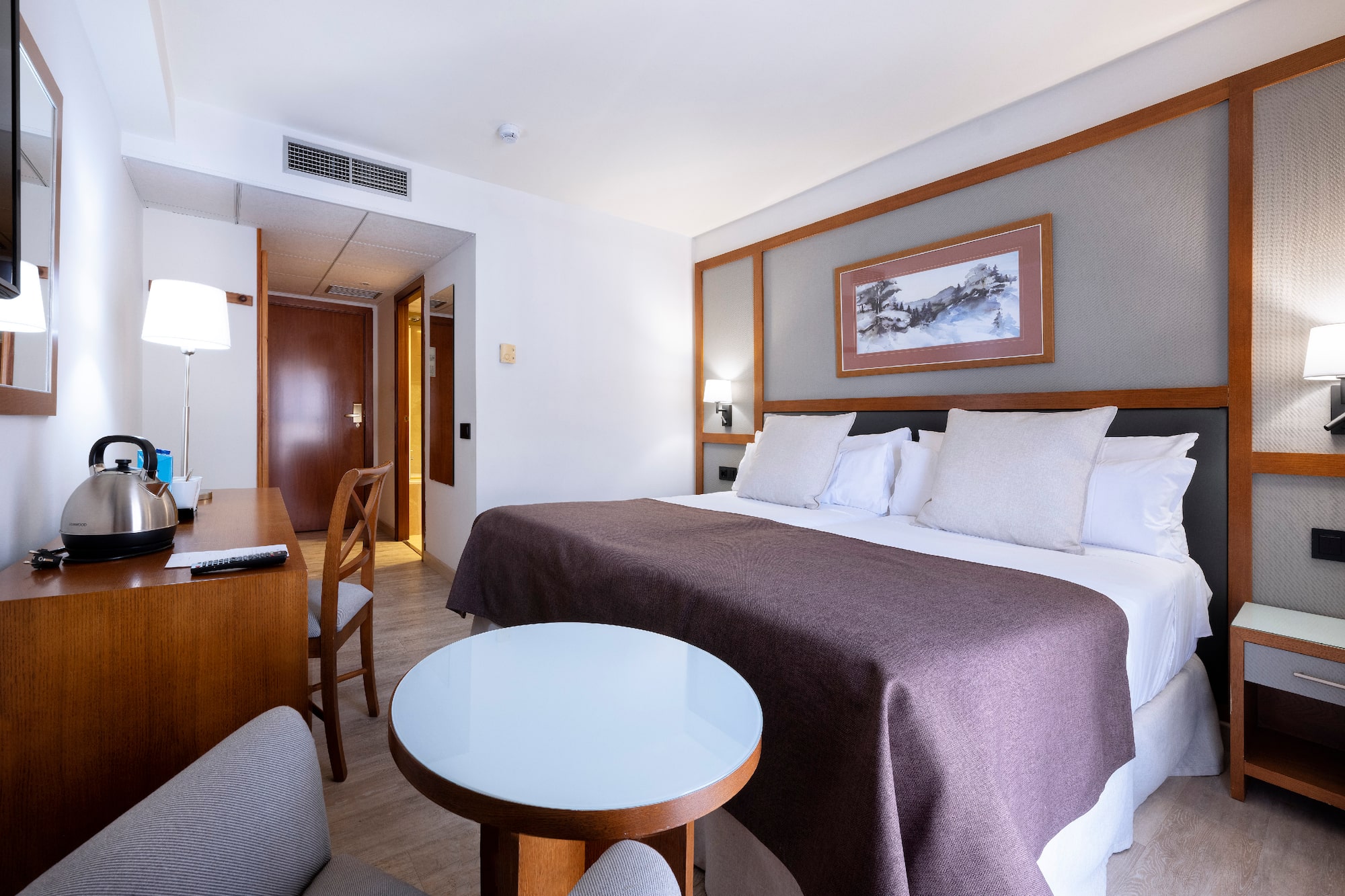 a room with a bed and chairs