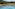 Resort swimming pool with lounge chairs, straw umbrellas, and hillside hotel.