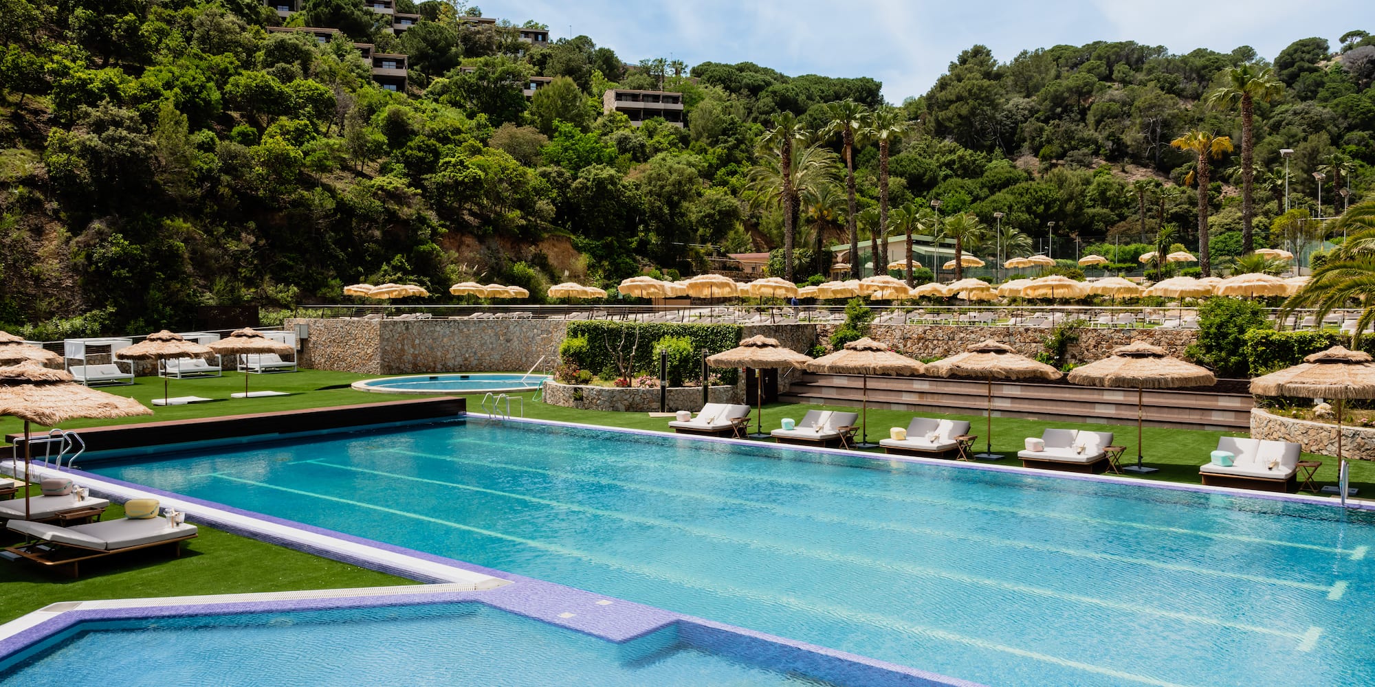 a pool with chairs and umbrellas in the background