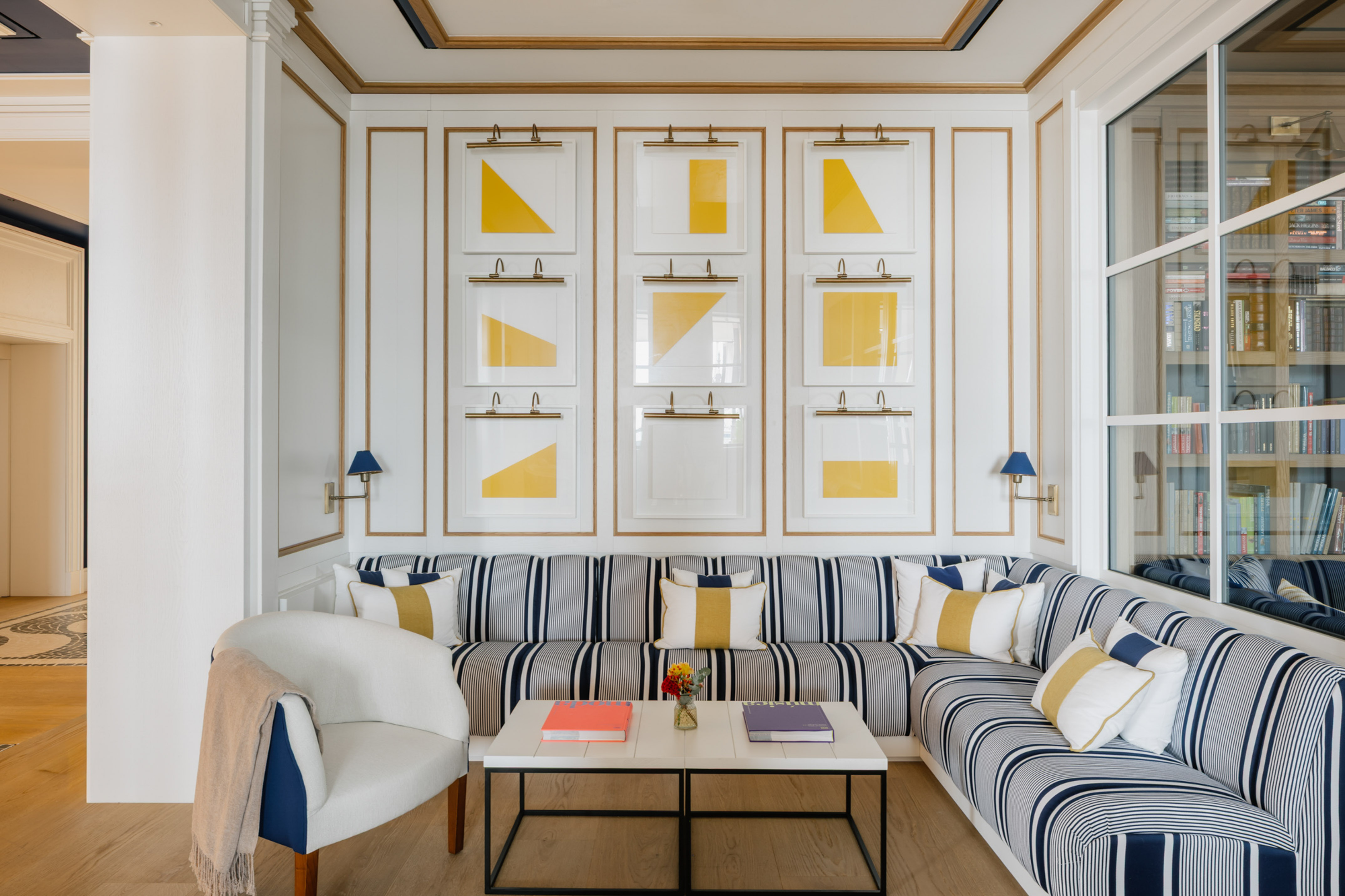 Nautical themed living room with blue striped sofa and yellow geometric art.