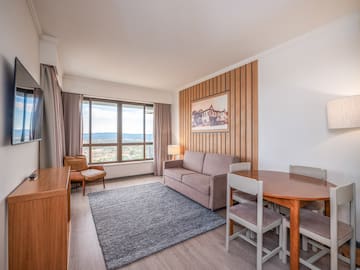 a room with a couch and table and chairs