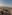 Rooftop bar with city and mountain view at sunset.